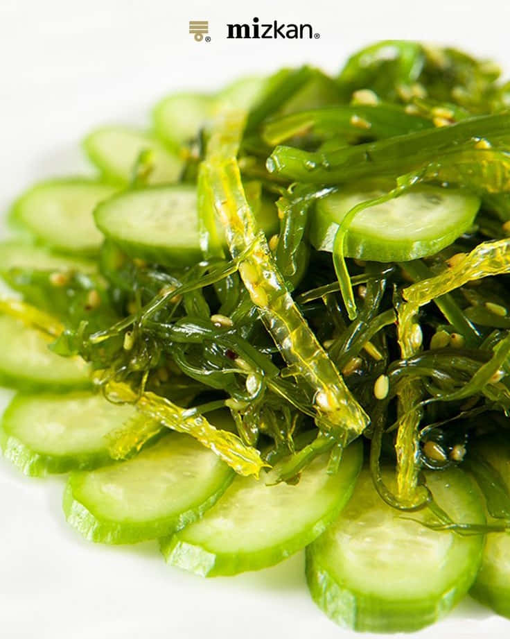 Seaweed 桌布 壁紙 — 一個充滿活力的特寫鏡頭，展示放在白色碟上的日本海藻青瓜沙律，並撒上芝麻作裝飾。