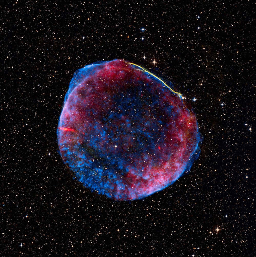 Supernova Explosion 桌布 壁紙 — 一個充滿活力的紅色和藍色宇宙星雲在深空的星場中發光。