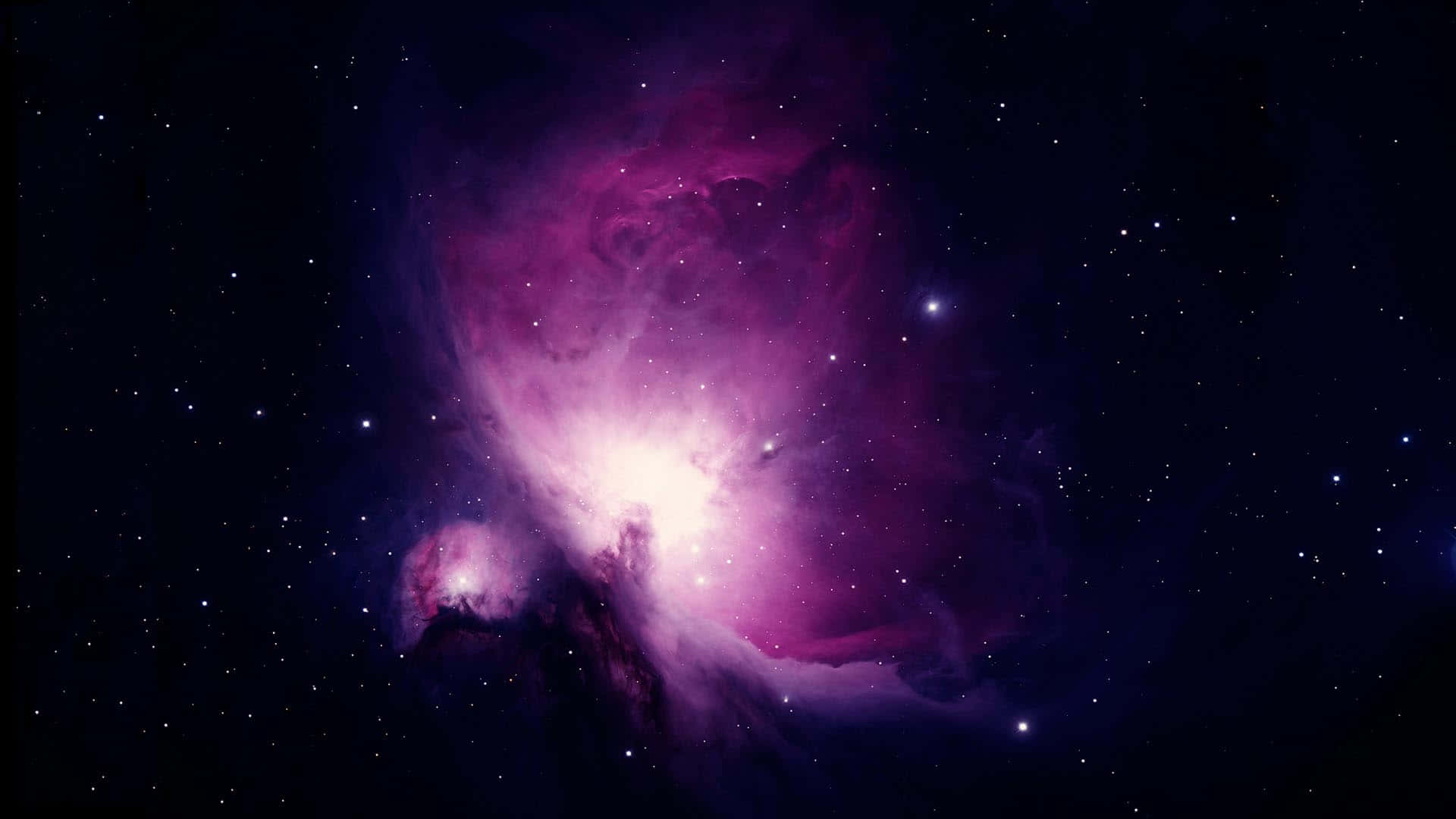 Purple Clouds 桌布 壁紙 — 一個充滿活力的紫色和粉紅色星雲在佈滿星辰的宇宙虛空中明亮地發光。