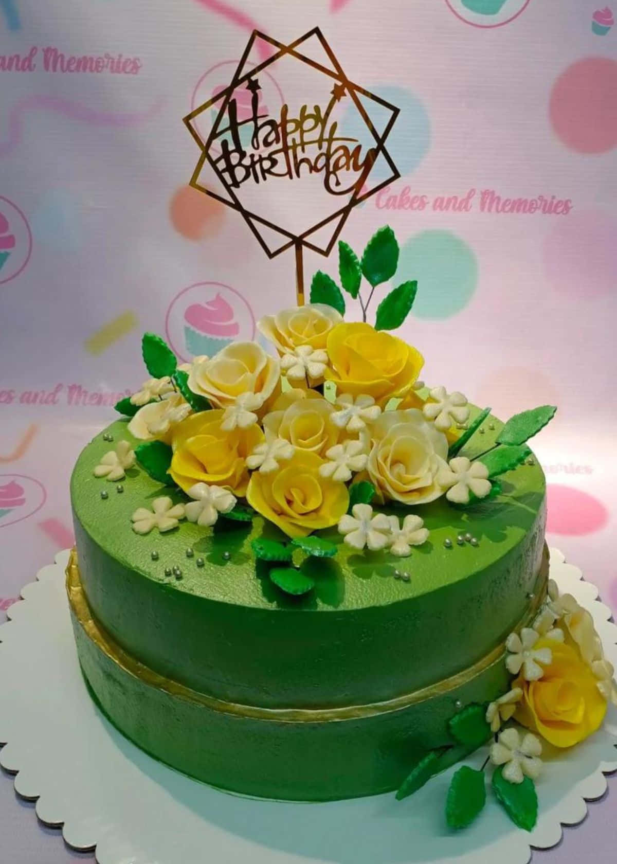 Floral Cake 桌布 壁紙 — 一個充滿活力的綠色糖霜生日蛋糕，飾有黃玫瑰和白花，上面有一個幾何裝飾。