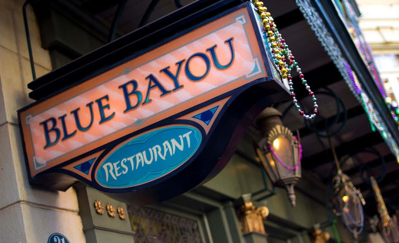 Blue Bayou 桌布 壁紙 — 一個充滿活力的華麗招牌，為Blue Bayou餐廳裝飾著彩色珠子和發光的燈籠。