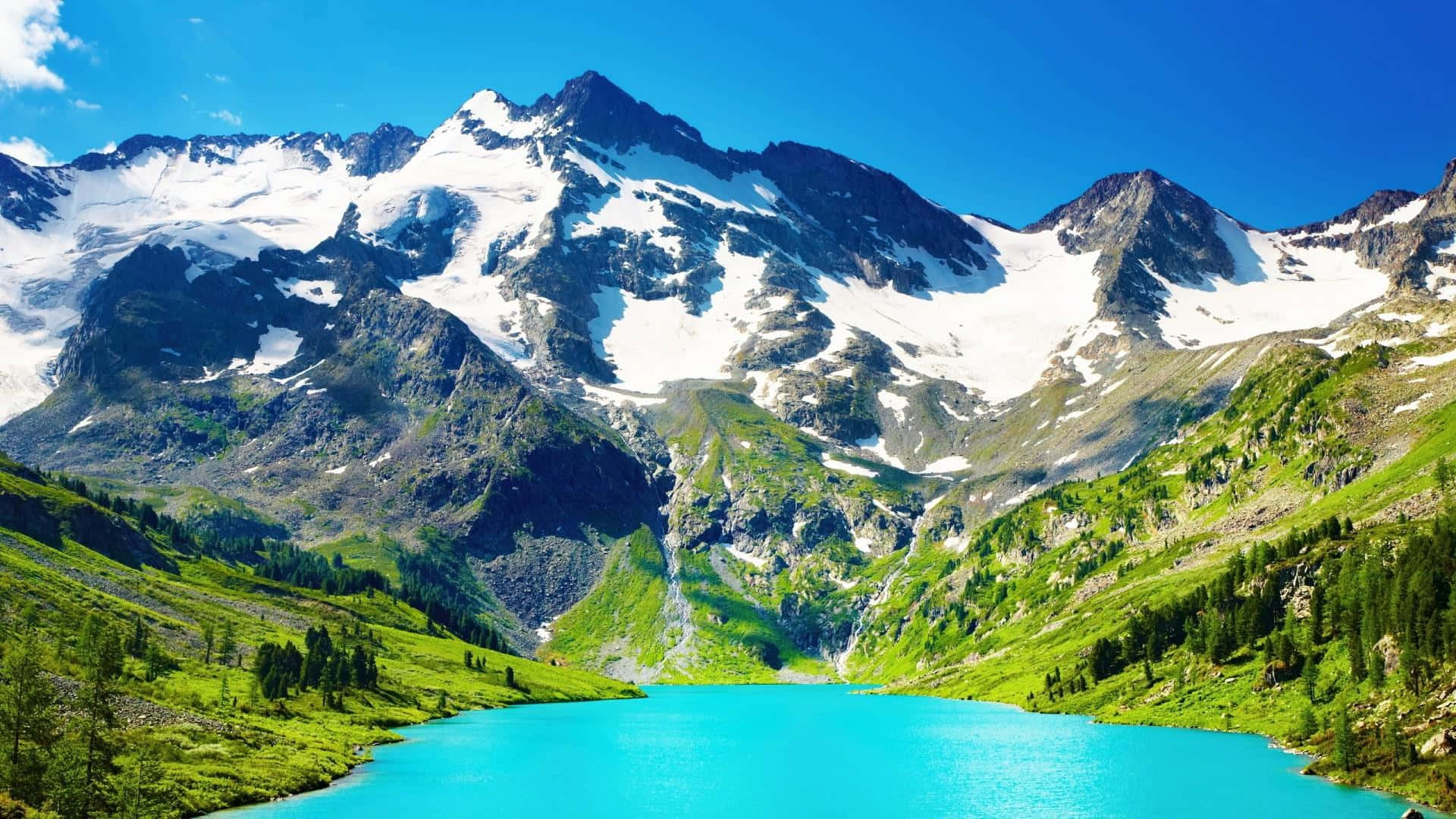 Beautiful Mountain 桌布 壁紙 — 一個充滿活力的藍綠色湖泊，坐落在白雪覆蓋的山峰下的山谷中，上方是清澈的藍天。