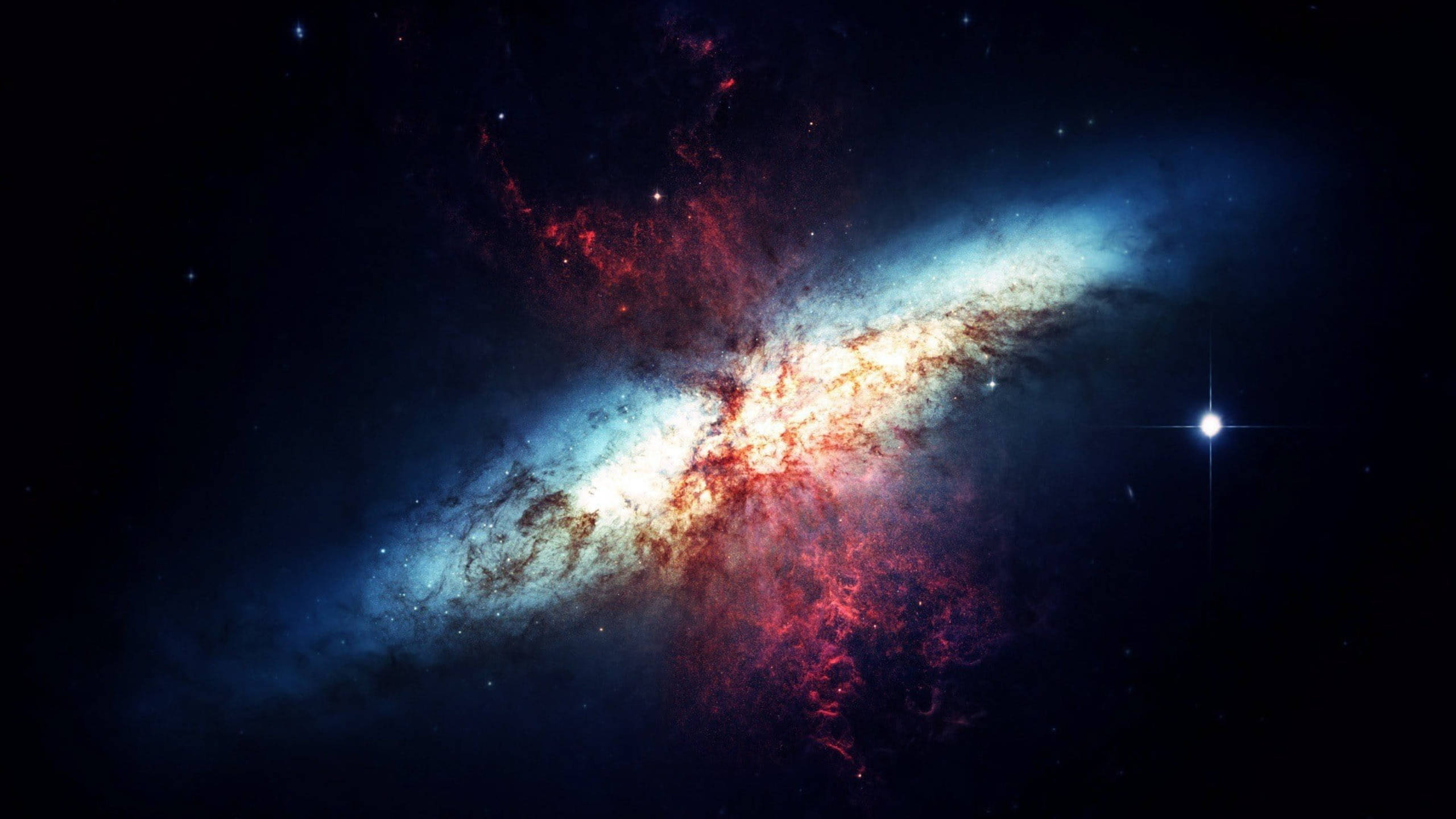 太空 桌布 壁紙 — 一個充滿活力的螺旋星系，在繁星點點的黑色虛空中旋轉著藍色和紅色的宇宙塵埃，附近有一顆明亮的恆星。