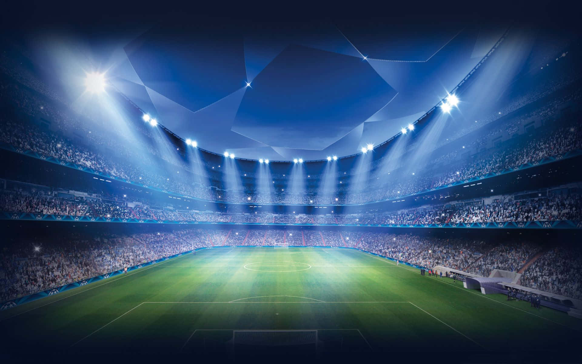Football Stadium 桌布 壁紙 — 一個充滿活力的足球場沐浴在明亮的藍色聚光燈下，照亮了翠綠的球場，周圍擠滿了歡呼的人群。