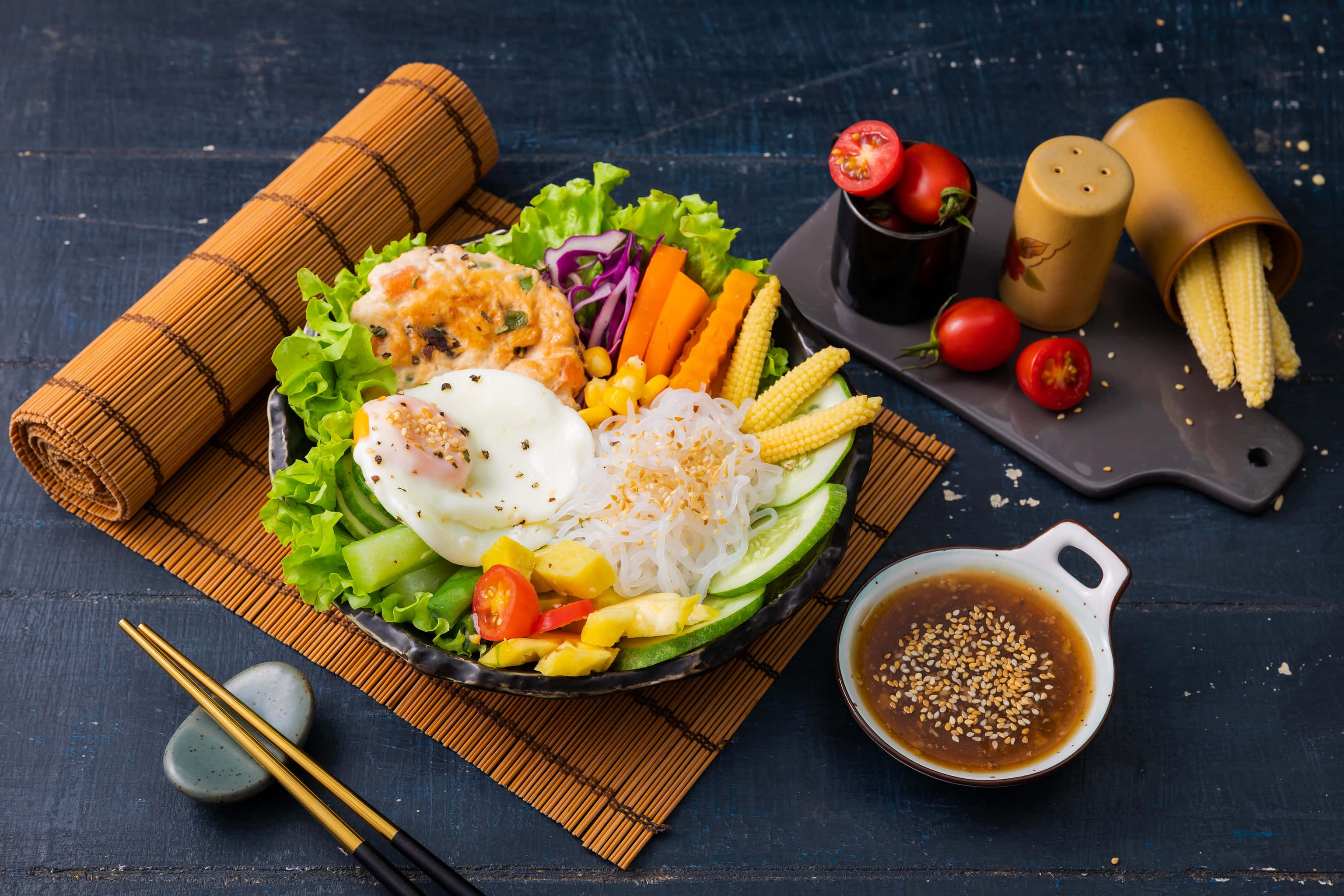 沙律 桌布 壁紙 — 一個充滿活力的韓式拌飯，上面放有水煮蛋、玉米、紅蘿蔔和新鮮蔬菜，放在深色木桌上。