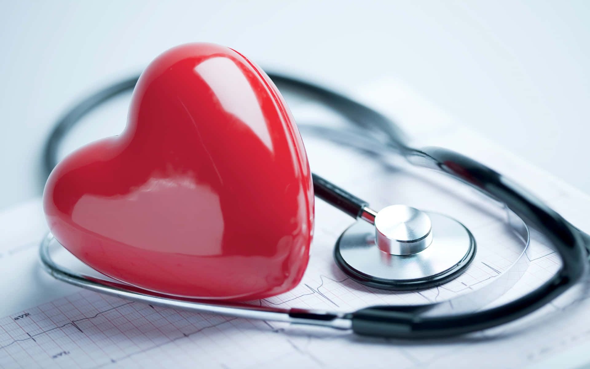 Health And Beauty 桌布 壁紙 — 一個光滑的紅色心形物體放在一個聽診器上，聽診器則掛在心電圖圖表上。