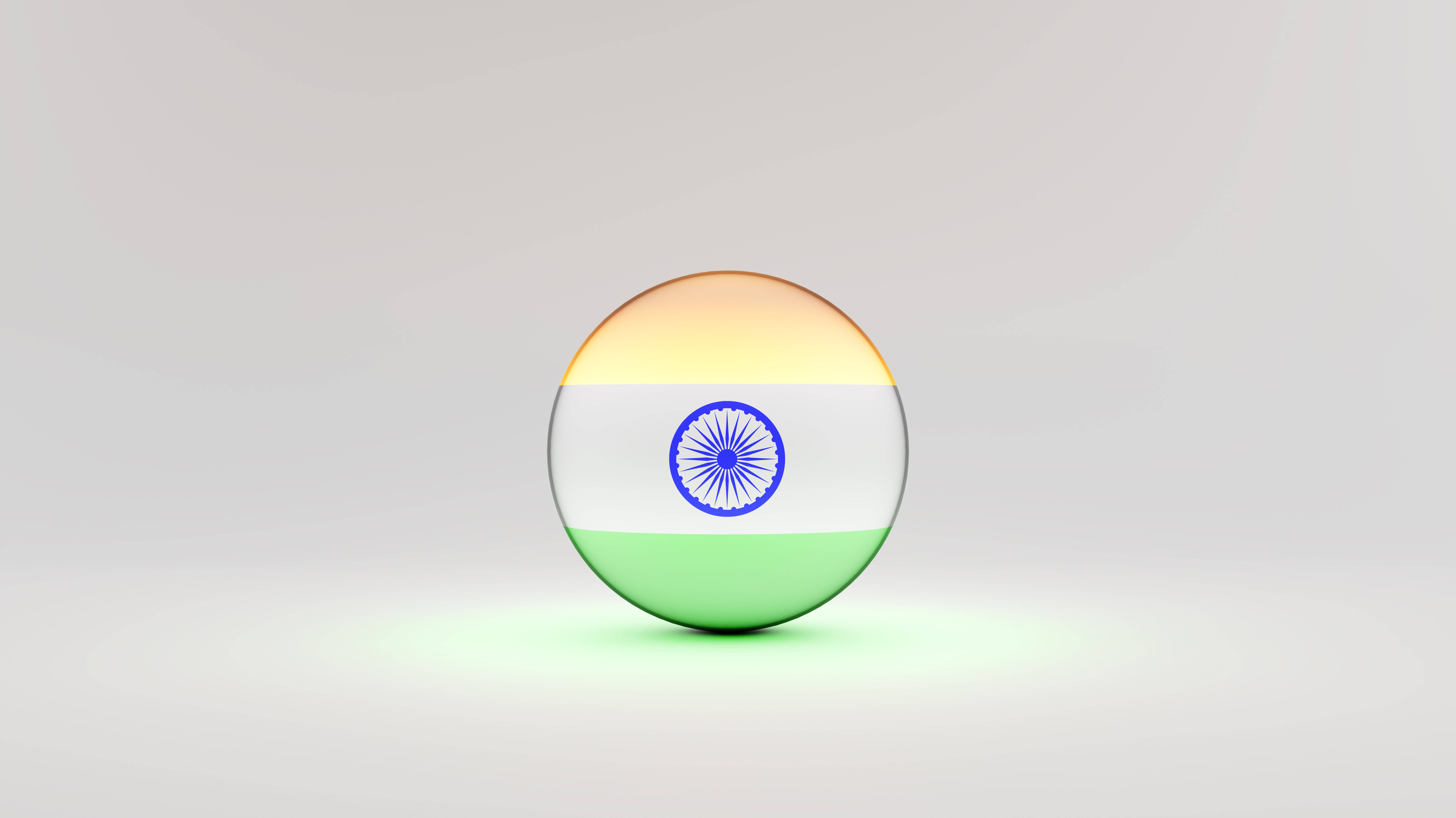 Indian 桌布 壁紙 — 一個光澤球體，展示印度三色旗，中央有阿育王法輪，置於中性工作室背景上。
