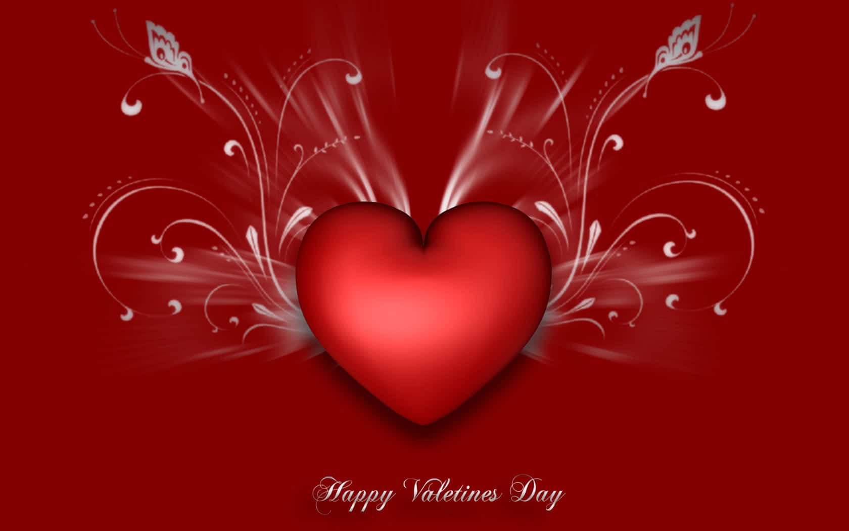 Happy Valentines Day 桌布 壁紙 — 一個光澤的紅色心形在深紅色背景上散發出白色華麗的漩渦，下方寫有「Happy Valentines Day」。
