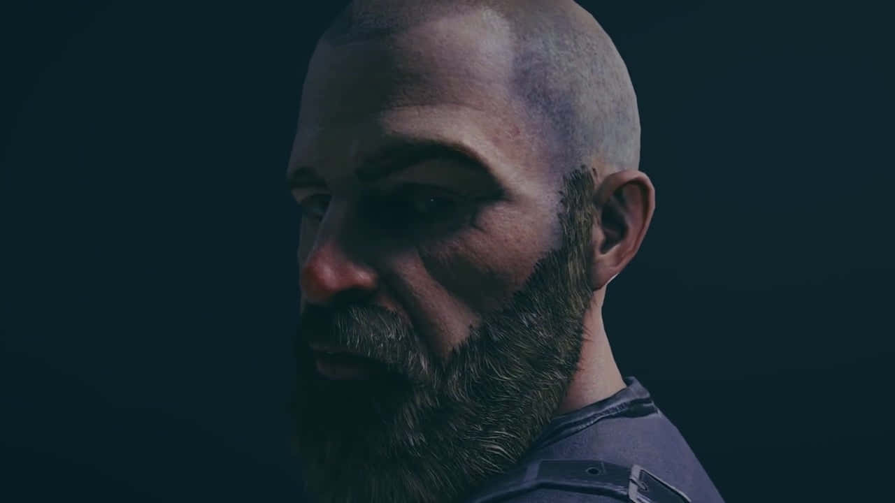 Rainbow Six Siege Bandit 桌布 壁紙 — 一個光頭男子，留著濃密鬍鬚，在昏暗燈光下，以深色背景為襯托的特寫。