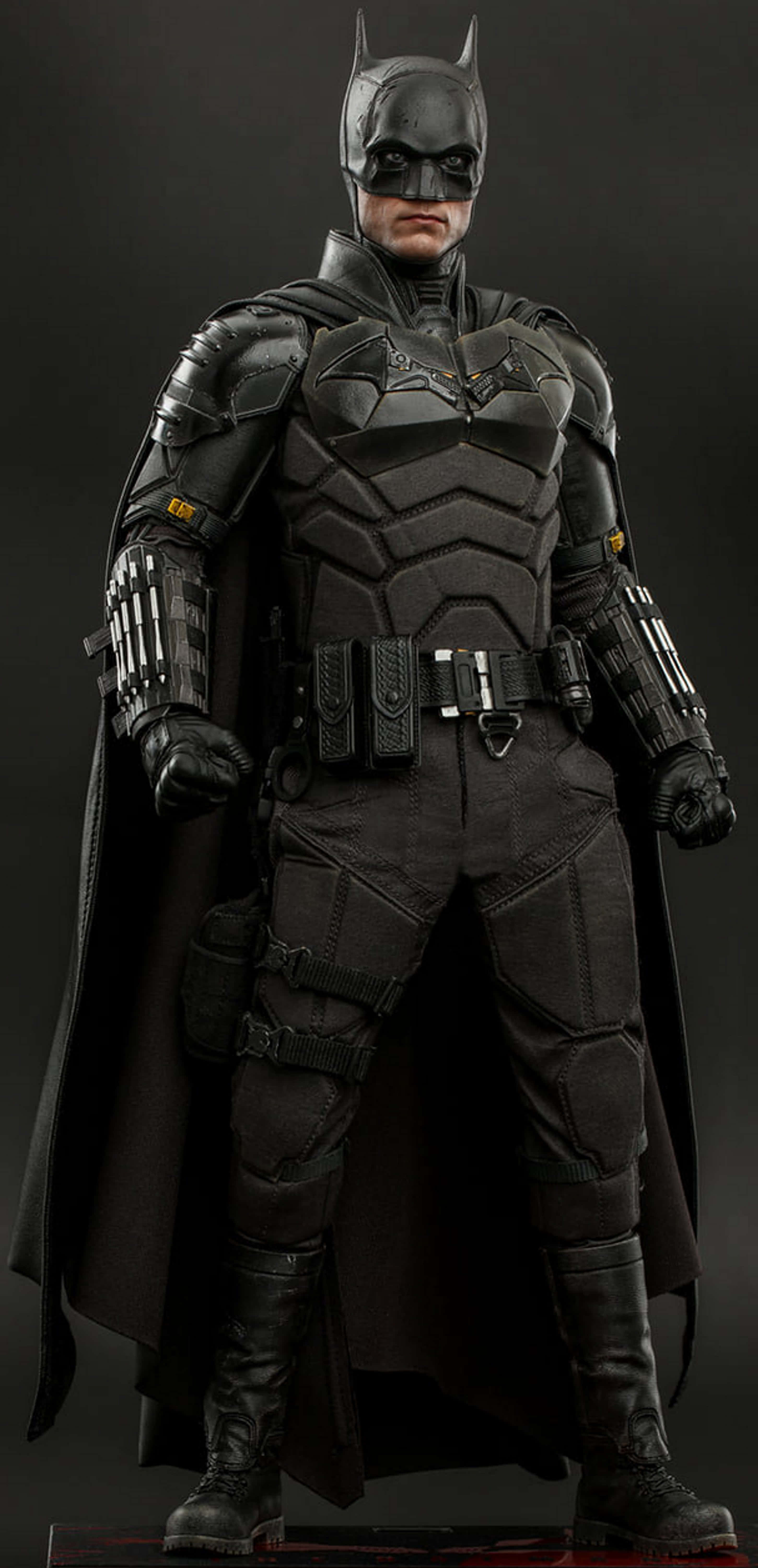 Bat-suit 桌布 壁紙 — 一個全身的蝙蝠俠可動人偶，穿著細節豐富的黑色裝甲服，在黑暗的攝影棚背景下擺好姿勢。