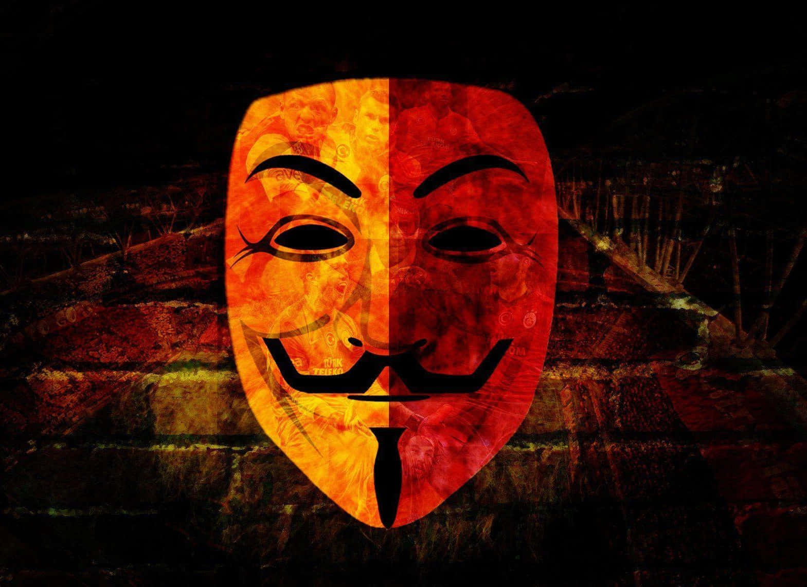 Anonymous 桌布 壁紙 — 一個分裂的蓋伊·福克斯面具在深色紋理磚牆背景下發出橙色和紅色的光芒。