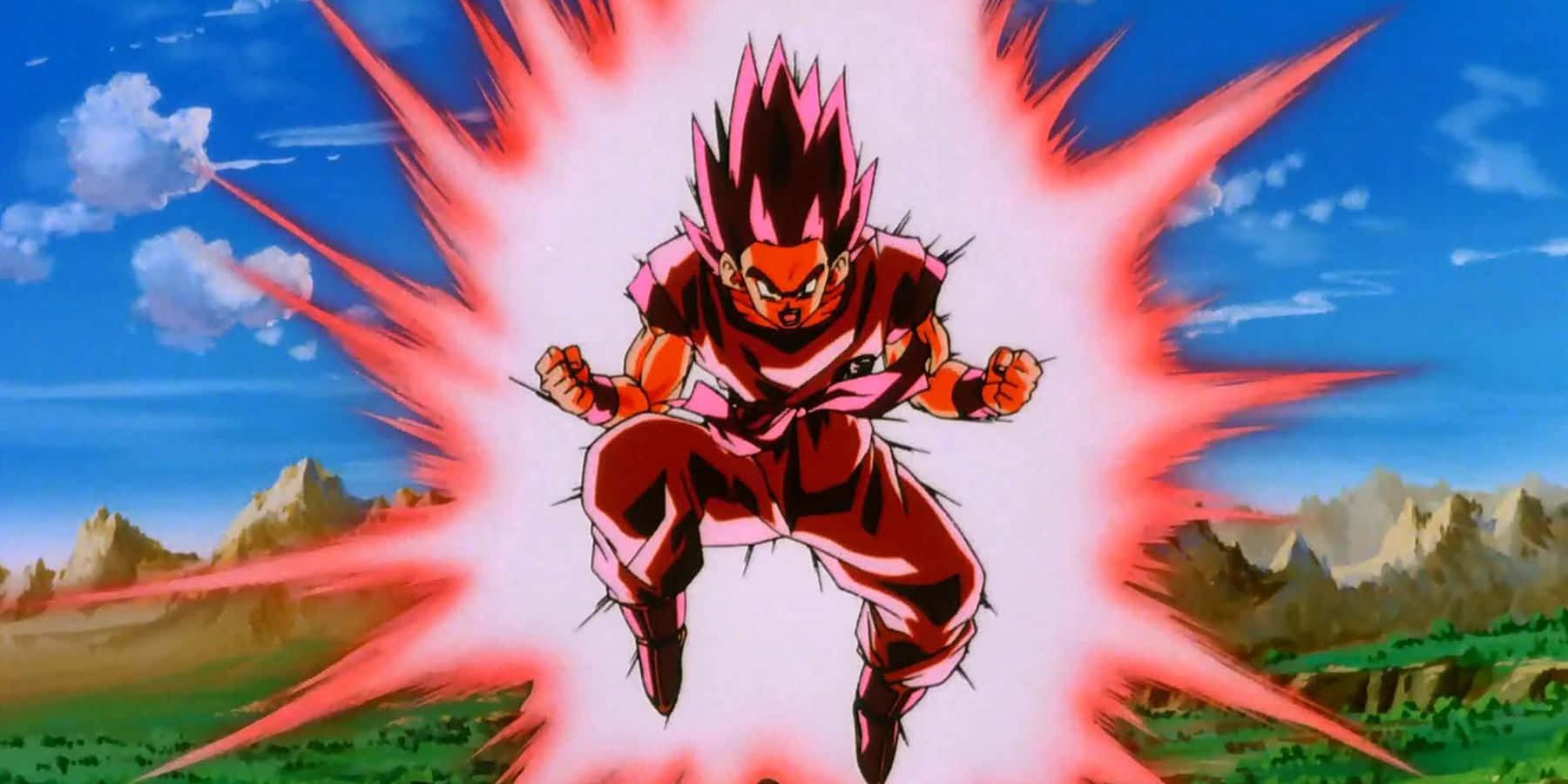 Goku Kaioken 桌布 壁紙 — 一個刺蝟頭動漫戰士身穿紅色盔甲，在藍天和遠山背景下散發出強烈的能量。