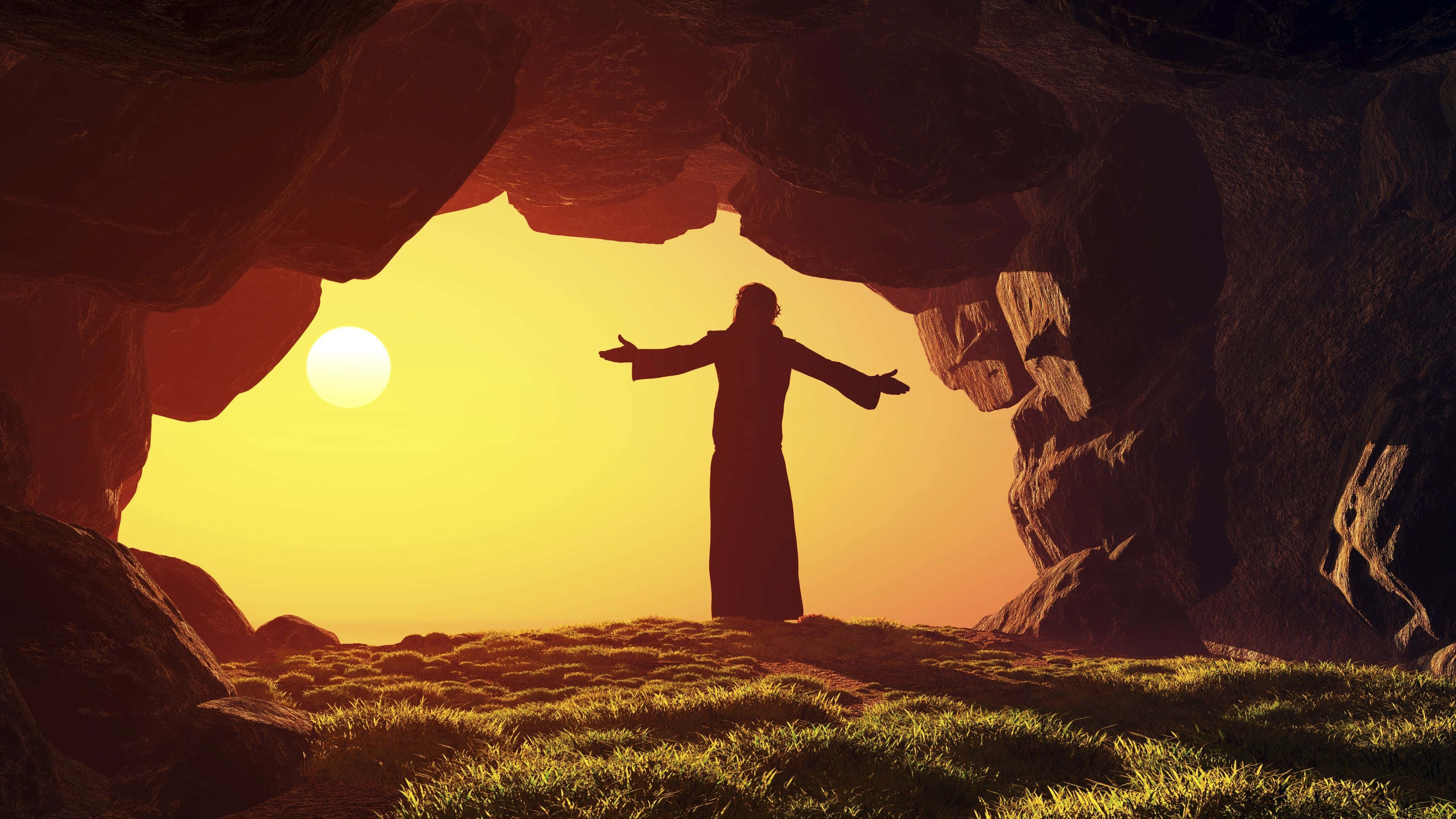 Religious Easter 桌布 壁紙 — 一個剪影人物在岩石洞穴中張開雙臂站立，背後一輪發光的太陽正在升起。
