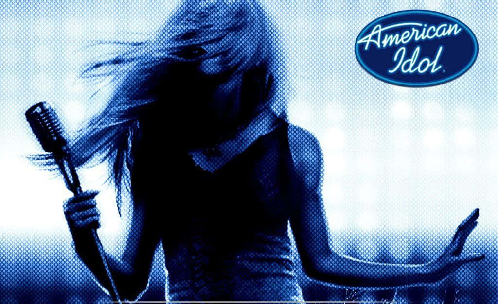 american idol 桌布 壁紙 — 一個剪影歌手，頭髮飄逸，在藍色調半色調風格的明亮舞台燈光下握著復古麥克風。