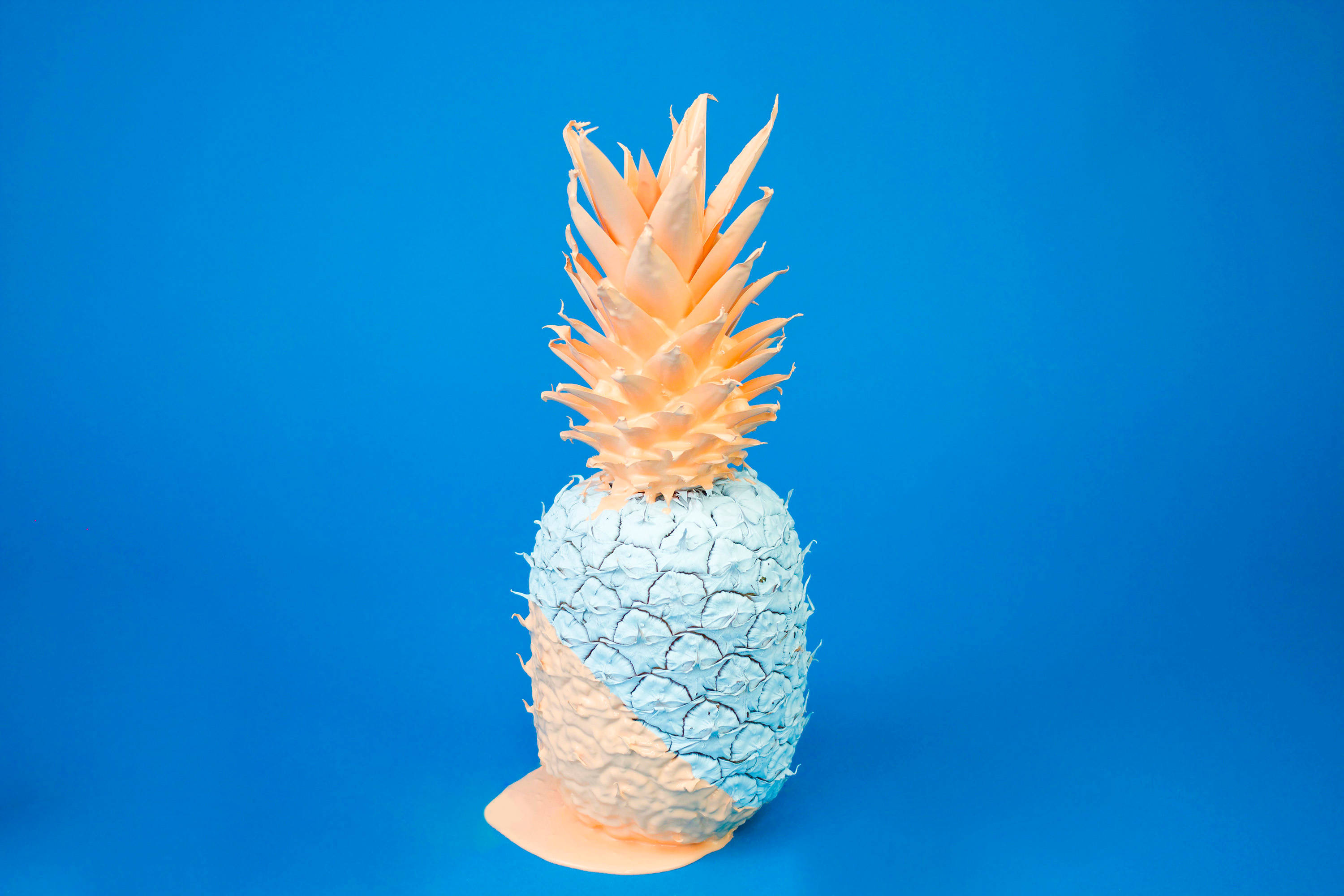 Pineapple 桌布 壁紙 — 一個半身塗成淺藍色的菠蘿，站在純藍色背景前。