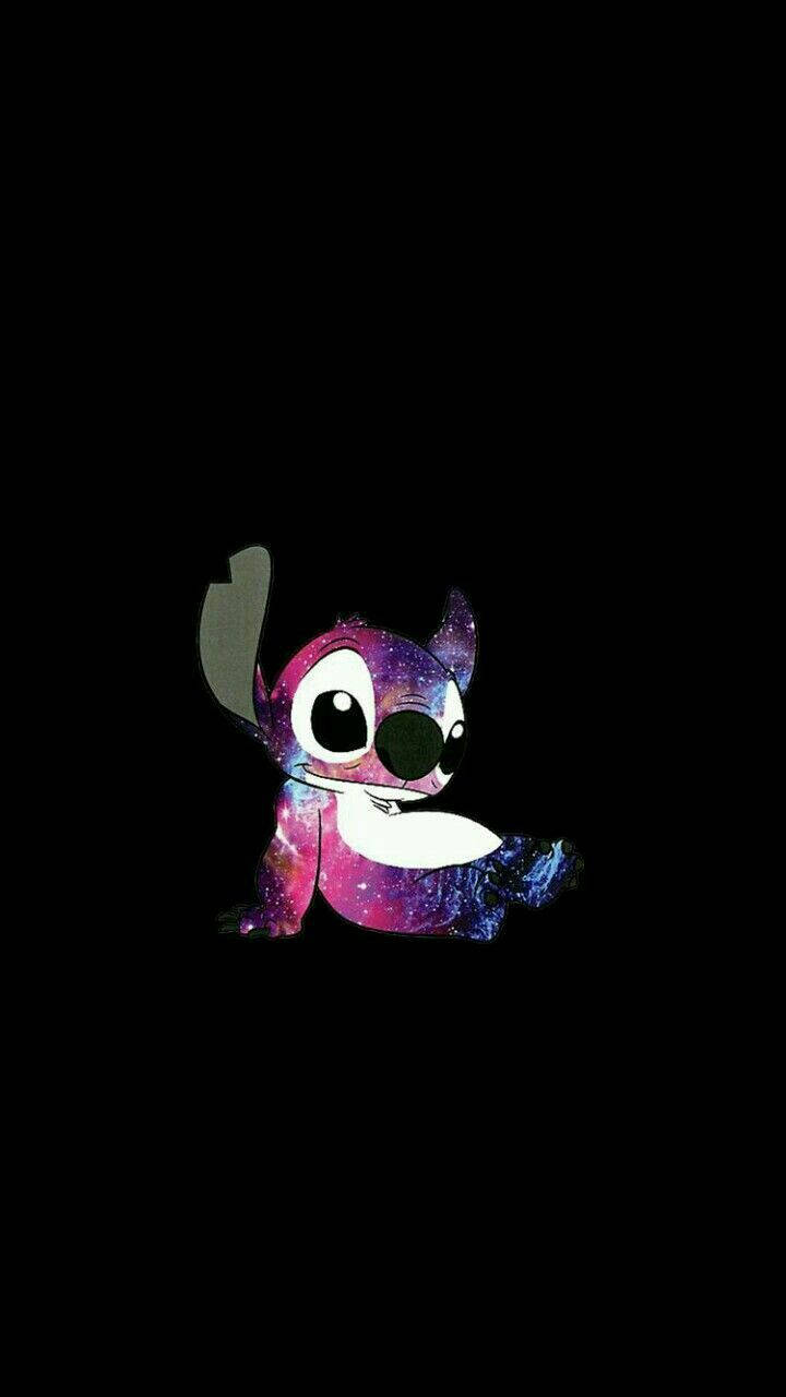 Cute Stitch 桌布 壁紙 — 一個卡通外星人身上有星系漩渦，坐在黑色背景前，表情頑皮。