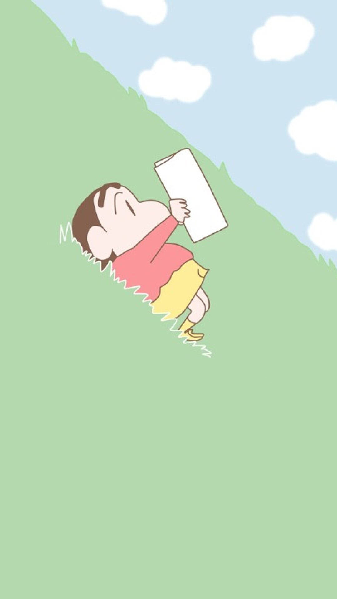 shinchan 桌布 壁紙 — 一個卡通男孩，穿著紅色襯衫和黃色短褲，在藍天白雲下的草地上抱著一本書，安詳地睡著。