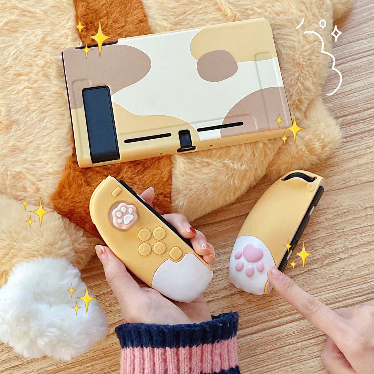 Gaming Accessories 桌布 壁紙 — 一個可愛貓咪主題的Nintendo Switch主機和控制器放在毛絨玩具上，由手拿著，周圍有閃光。