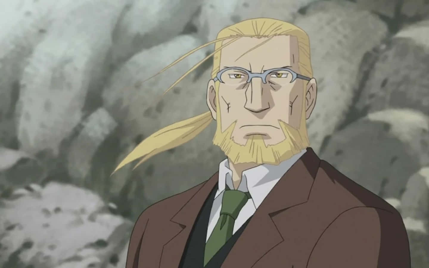Van Hohenheim 桌布 壁紙 — 一個嚴肅的動漫男人，金髮戴眼鏡，站在岩石背景前，穿著棕色西裝和綠色領帶。