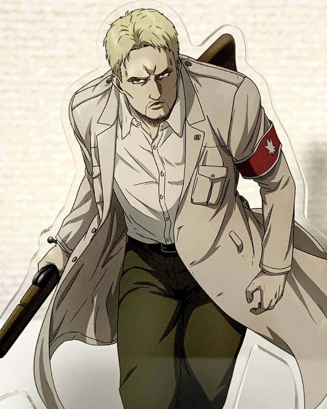 Reiner Braun 桌布 壁紙 — 一個嚴肅的金髮動漫男人，穿著米色風衣和紅色臂章，專注地握著步槍。