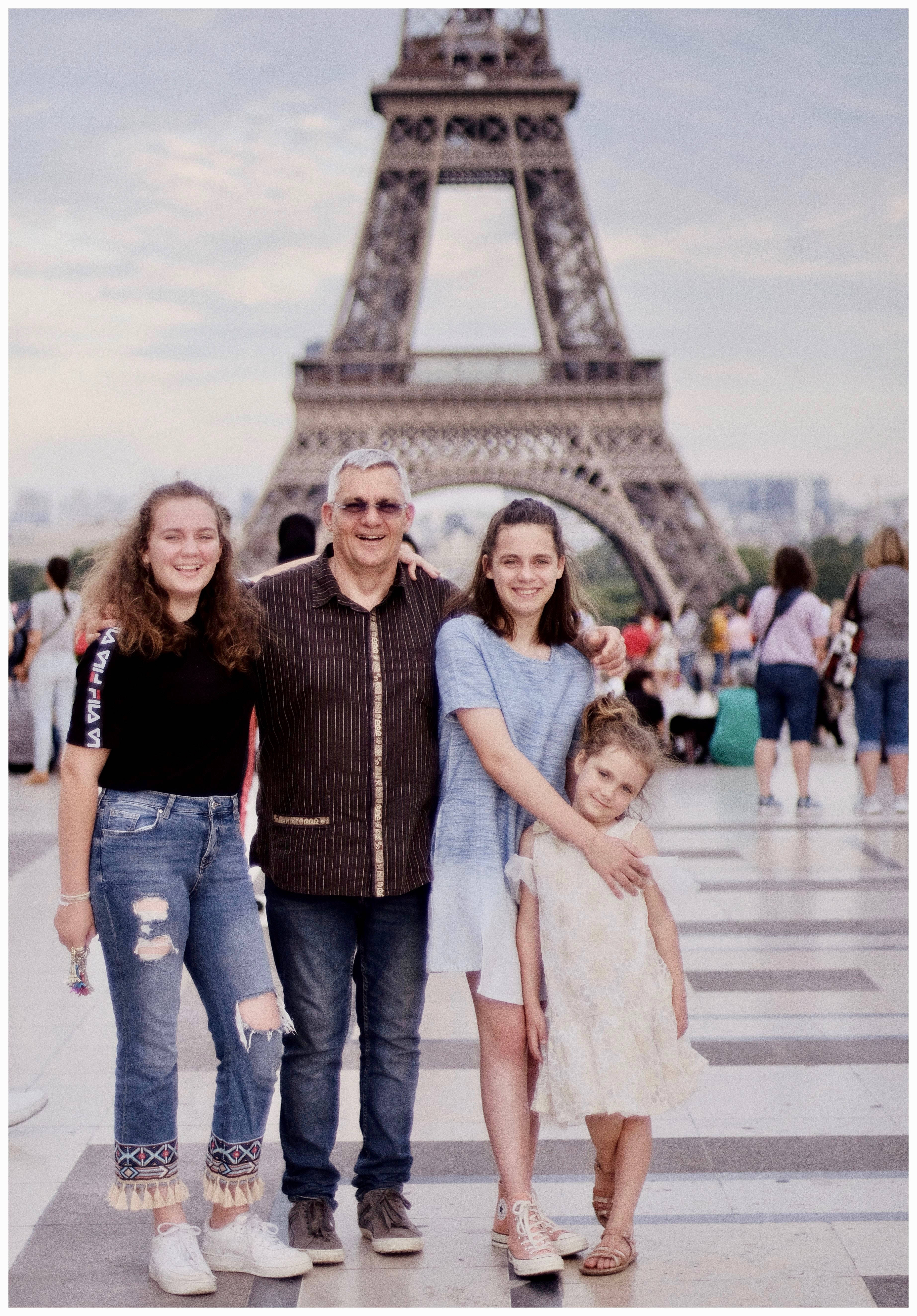 Family 桌布 壁紙 — 一個四口之家在晴朗的日子裡一起在艾菲爾鐵塔前微笑合影。