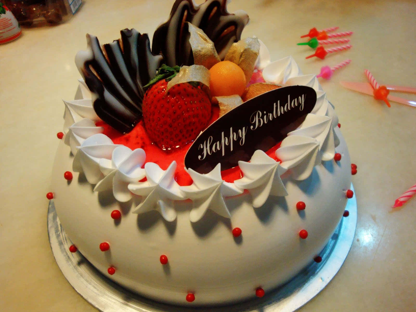  壁紙 — 一個圓形生日蛋糕，上面有忌廉、士多啤梨、朱古力和一塊「Happy Birthday」牌。