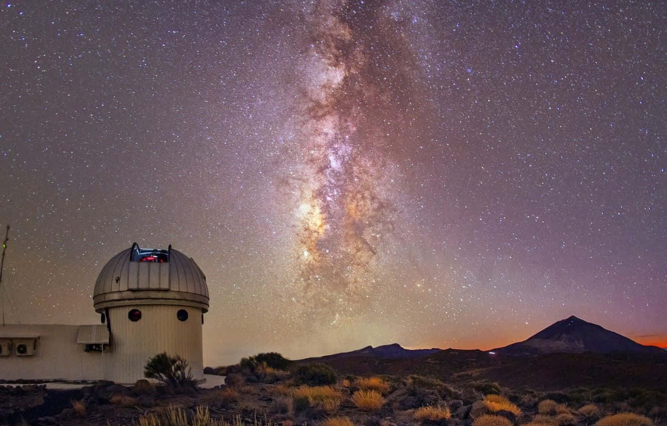 Space Observation 桌布 壁紙 — 一個圓頂天文台矗立在沙漠中，壯麗的銀河橫跨繁星點點的暮色天空。
