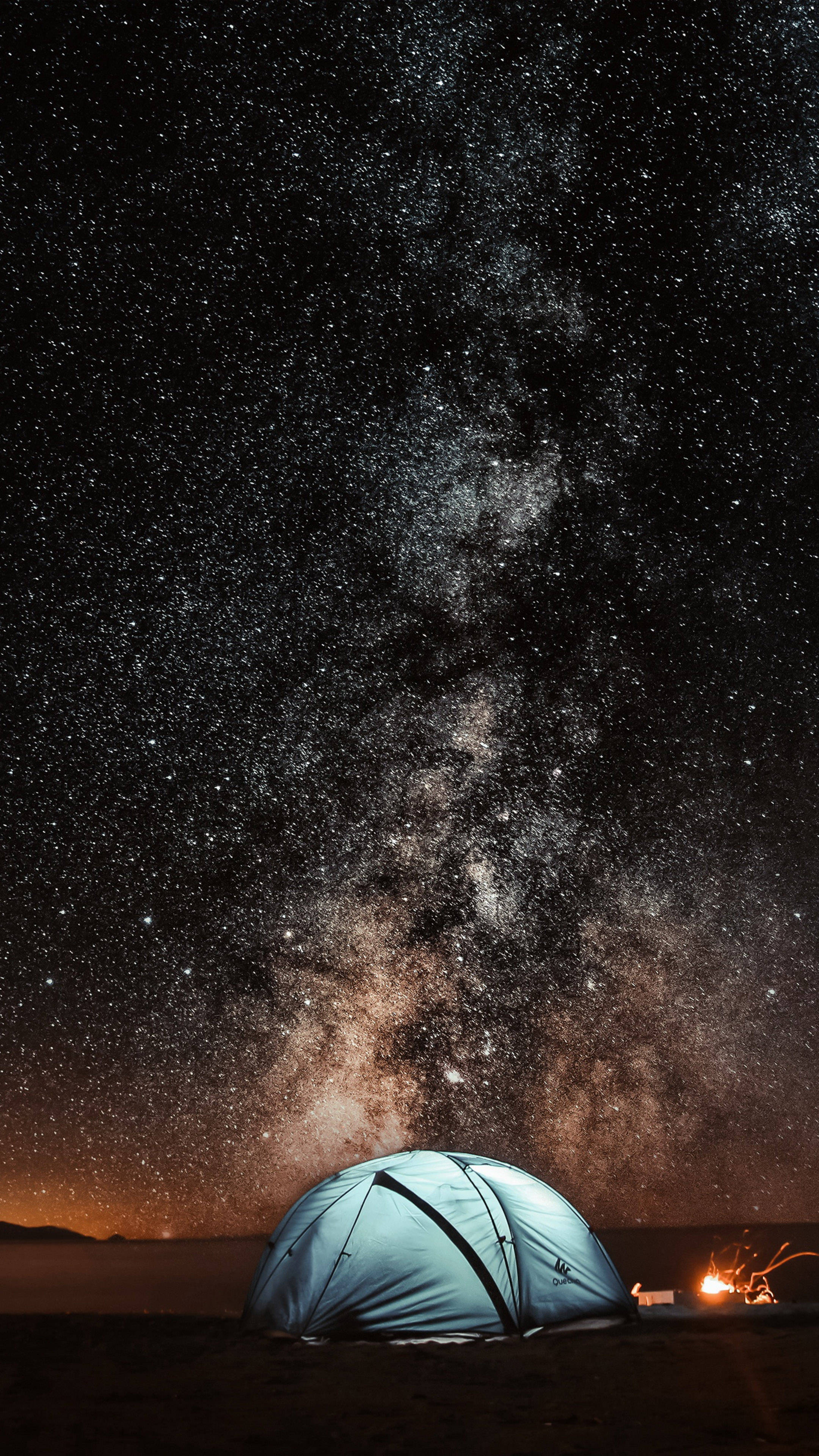 4K 桌布 壁紙 — 一個圓頂帳篷，在令人驚嘆的星空下，銀河在頭頂拱起，附近有營火在發光。