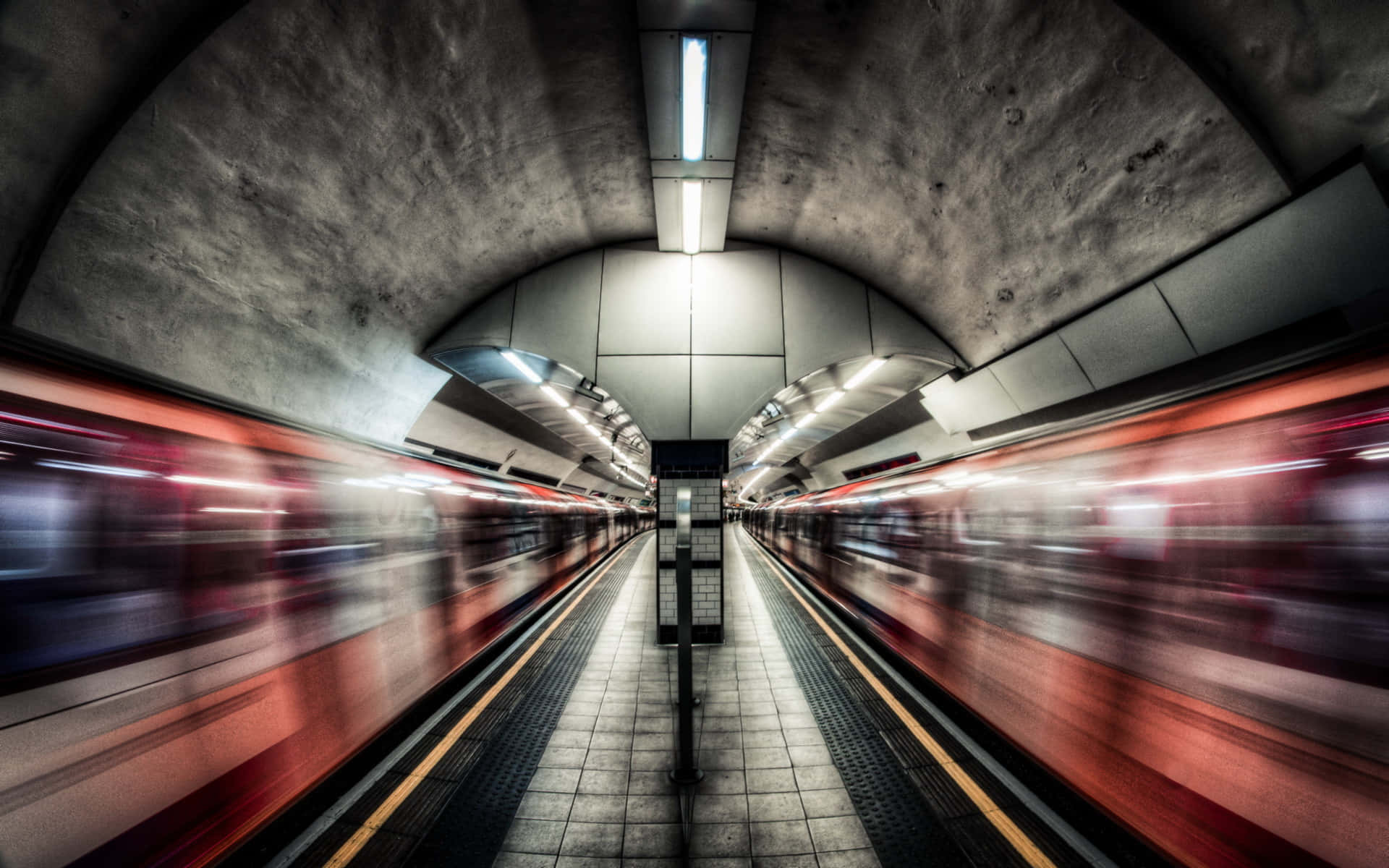 Subway 桌布 壁紙 — 一個地鐵站，列車在刺眼的螢光燈下以紅色線條模糊駛過。