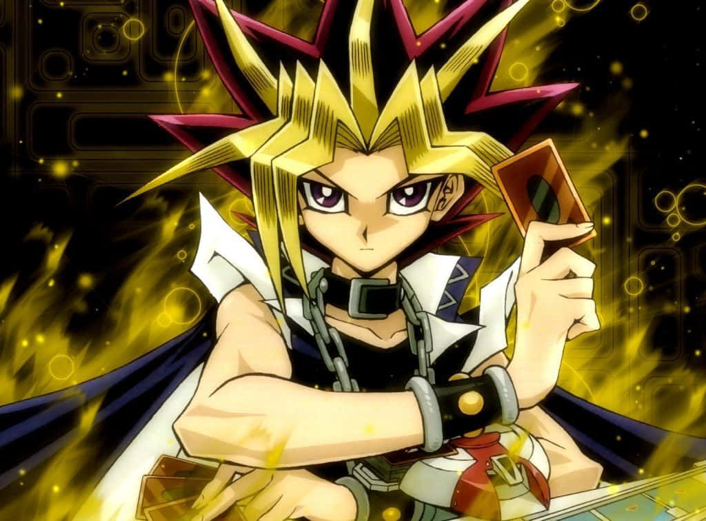 Yugi Muto 桌布 壁紙 — 一個堅定的動畫男孩，擁有尖刺的金色和紫色頭髮，在火熱的金色背景前拿著一張發光的卡牌。