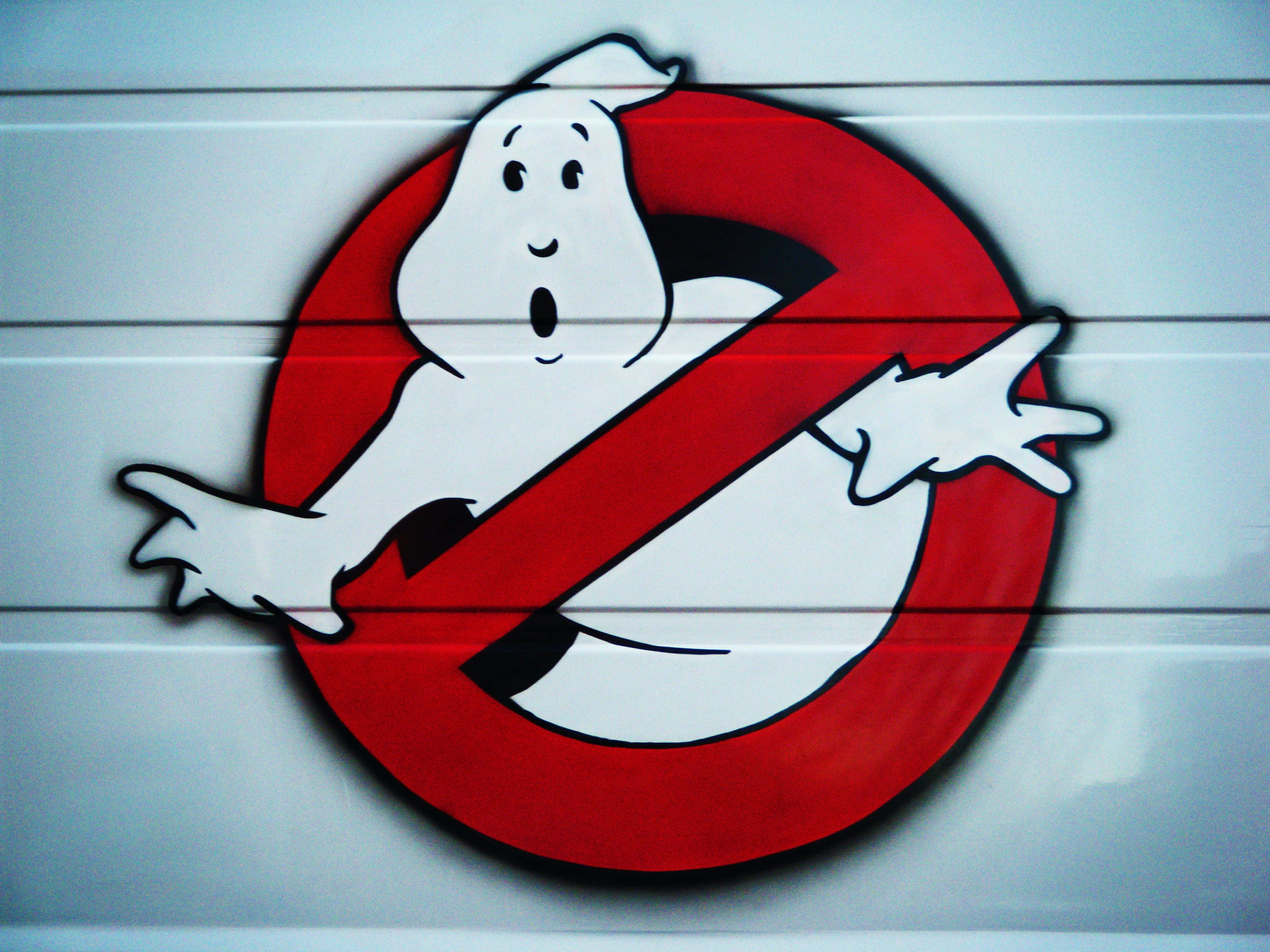 Ghostbusters 桌布 壁紙 — 一個塗鴉的Ghostbusters標誌，在白色鑲板牆上有一個紅色禁止符號，裡面有一隻驚訝的鬼魂。