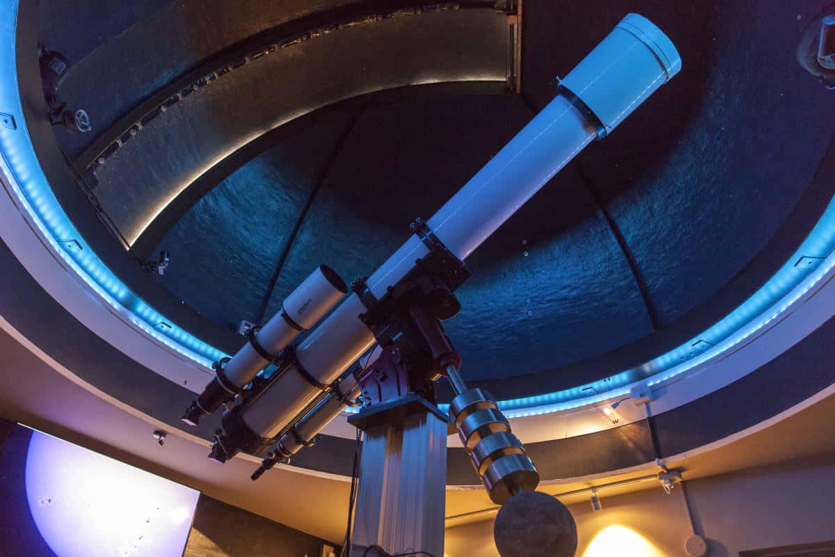 Observatory 桌布 壁紙 — 一個大型望遠鏡主導著圓頂天文台的內部，以冷藍色燈光和溫暖的環境光輝照亮。