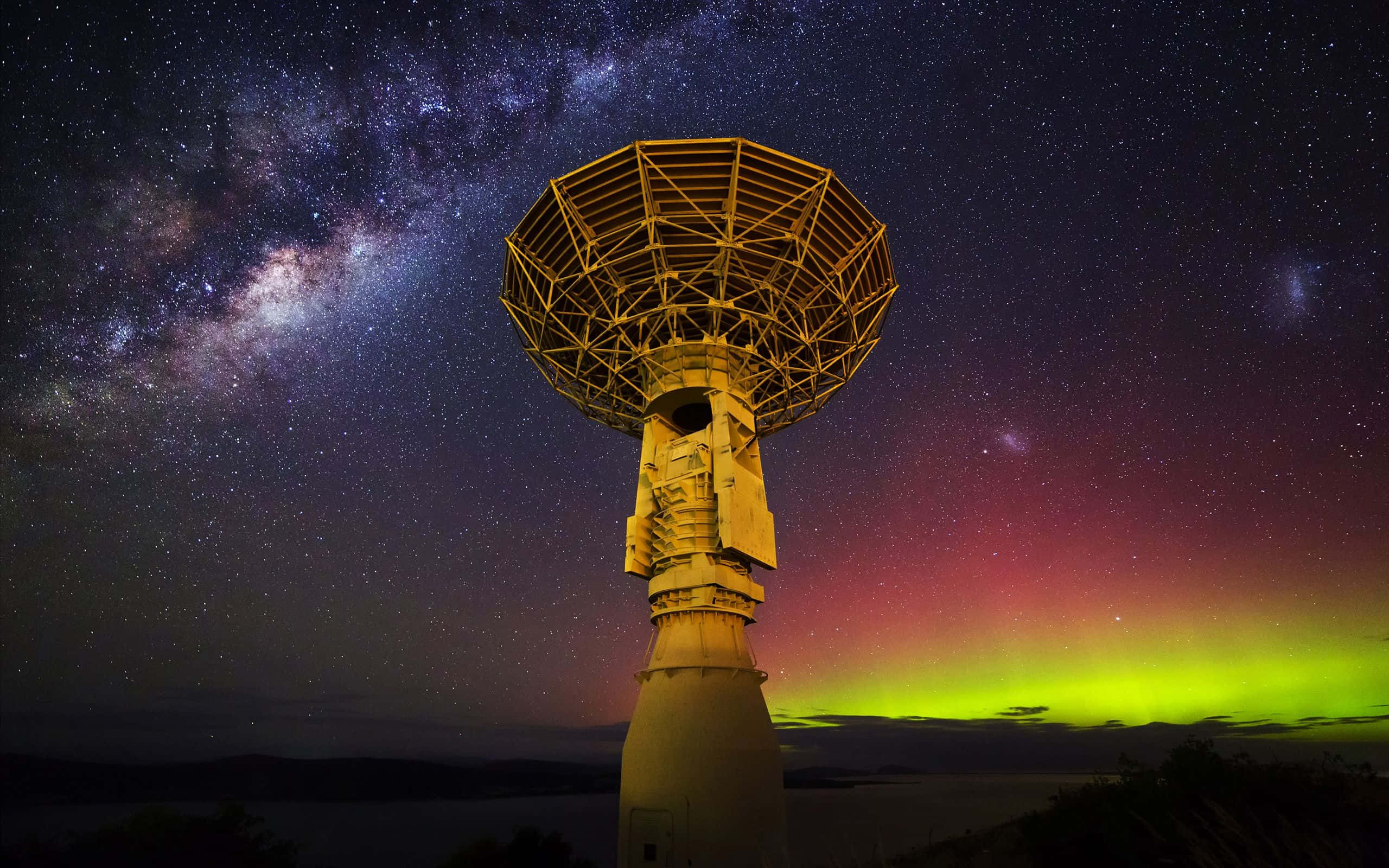 Space Observation 桌布 壁紙 — 一個大型無線電望遠鏡聳立在繁星點點的夜空下，上方有鮮豔的綠色極光和銀河閃耀。
