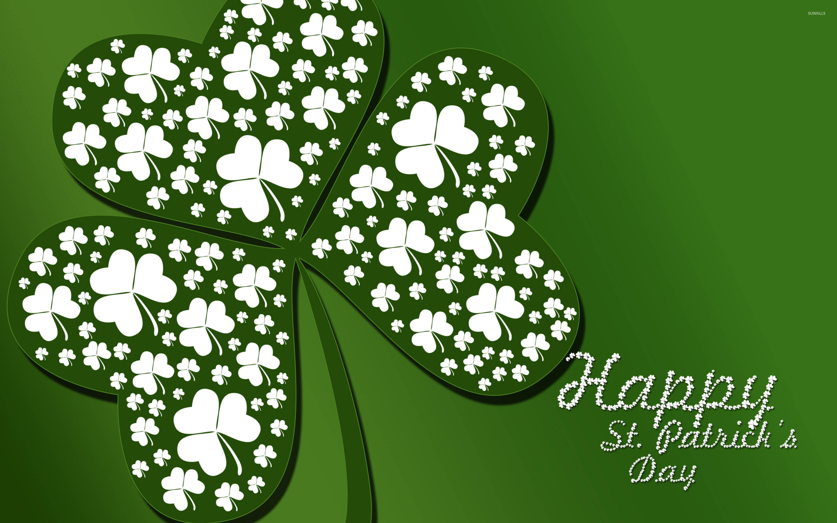 Happy St Patricks Day 桌布 壁紙 — 一個大型白色四葉草，上面有較小的三葉草圖案，背景為純綠色，並帶有「Happy St. Patrick's Day」文字。