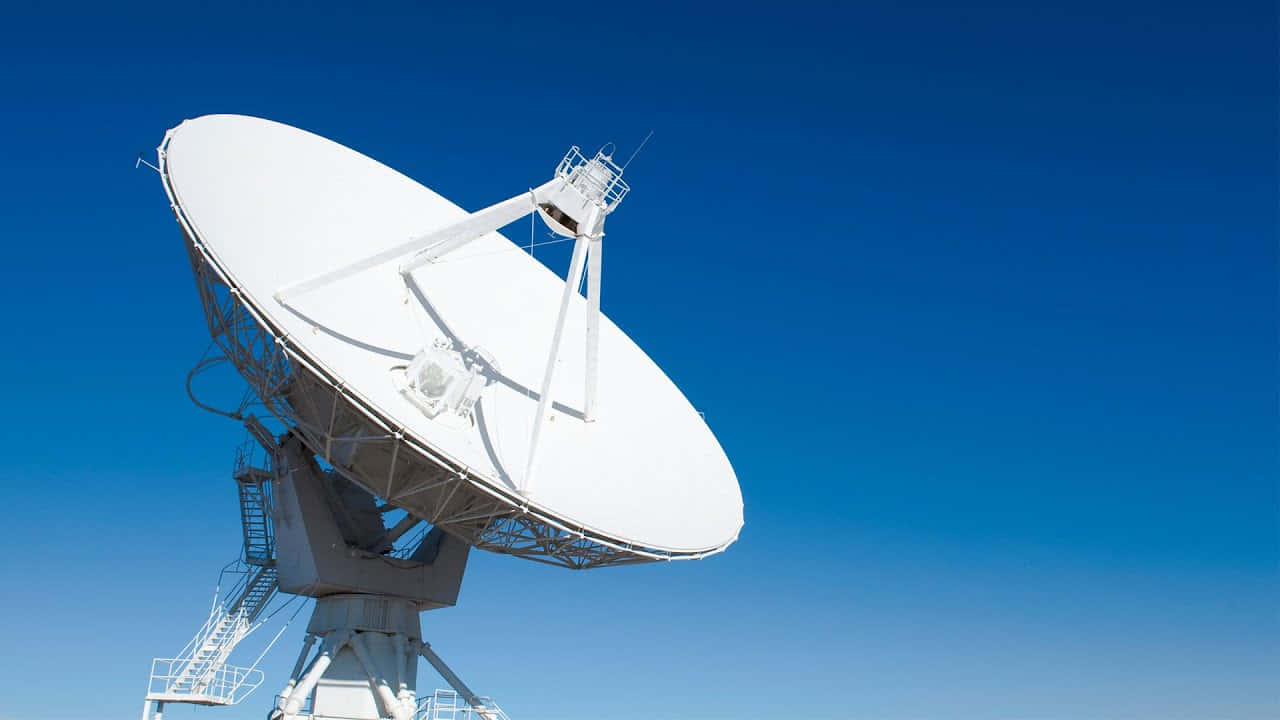 Satellite Technology 桌布 壁紙 — 一個大型白色衛星天線在明亮的日光下，高聳於清澈的藍天之中。