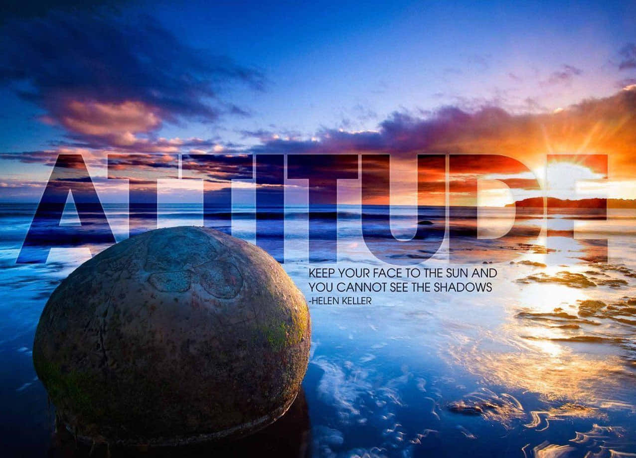動力 桌布 壁紙 — 一個大石球在日落時分位於淺水中，上面覆蓋著「ATTITUDE」一詞，下方是海倫·凱勒的名言。