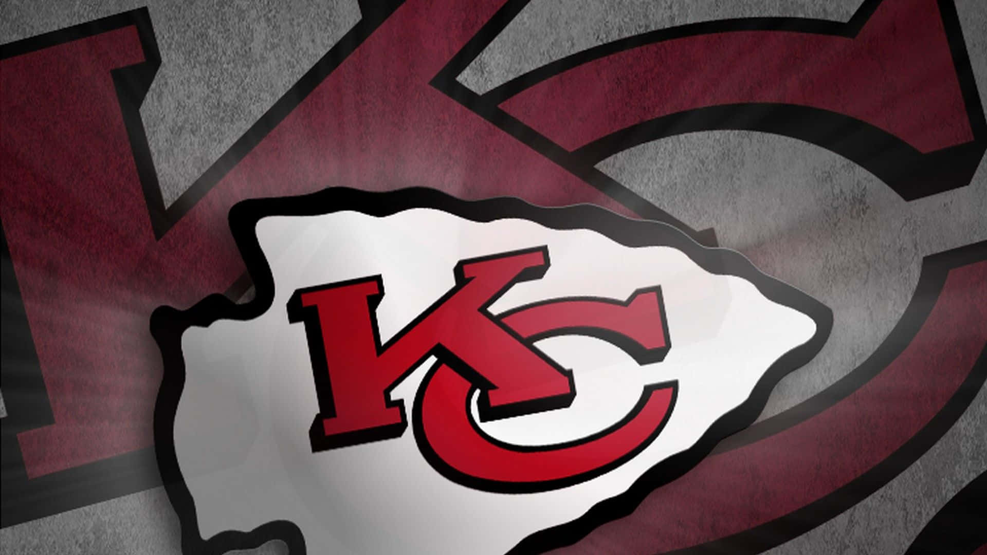 Kansas City Chiefs 桌布 壁紙 — 一個大膽的堪薩斯城酋長隊標誌，採用紅色和銀色，背景為紋理灰色。