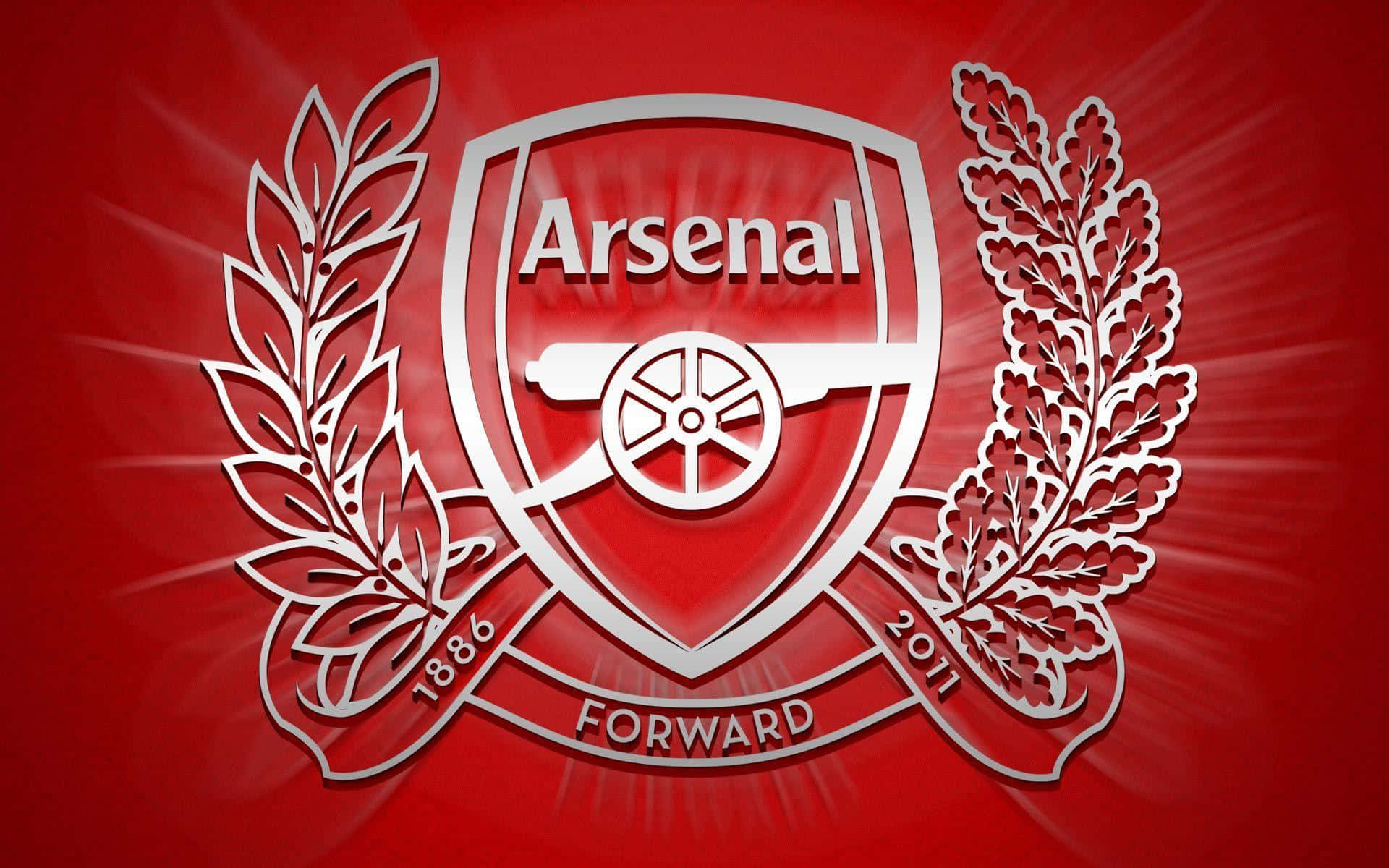 Arsenal 桌布 壁紙 — 一個大膽的白色阿仙奴FC徽章，帶有大炮和月桂花環，在充滿活力的紅色放射背景上發光。