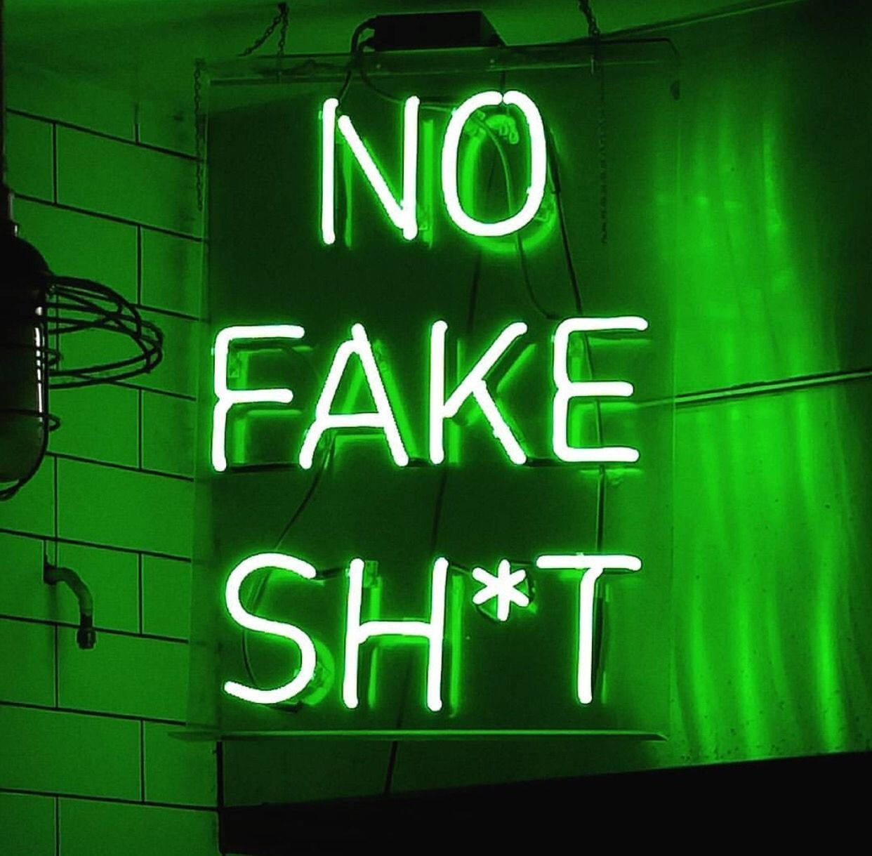 lights 桌布 壁紙 — 一個大膽的綠色霓虹燈牌，上面寫著 'NO FAKE SH*T'，在昏暗的空間中對著瓷磚牆發光。