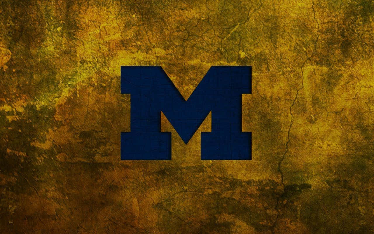 Michigan Wolverines 桌布 壁紙 — 一個大膽的藍色方塊M標誌居中放置在風化的金棕色紋理背景上，帶有裂紋和剝落油漆效果。