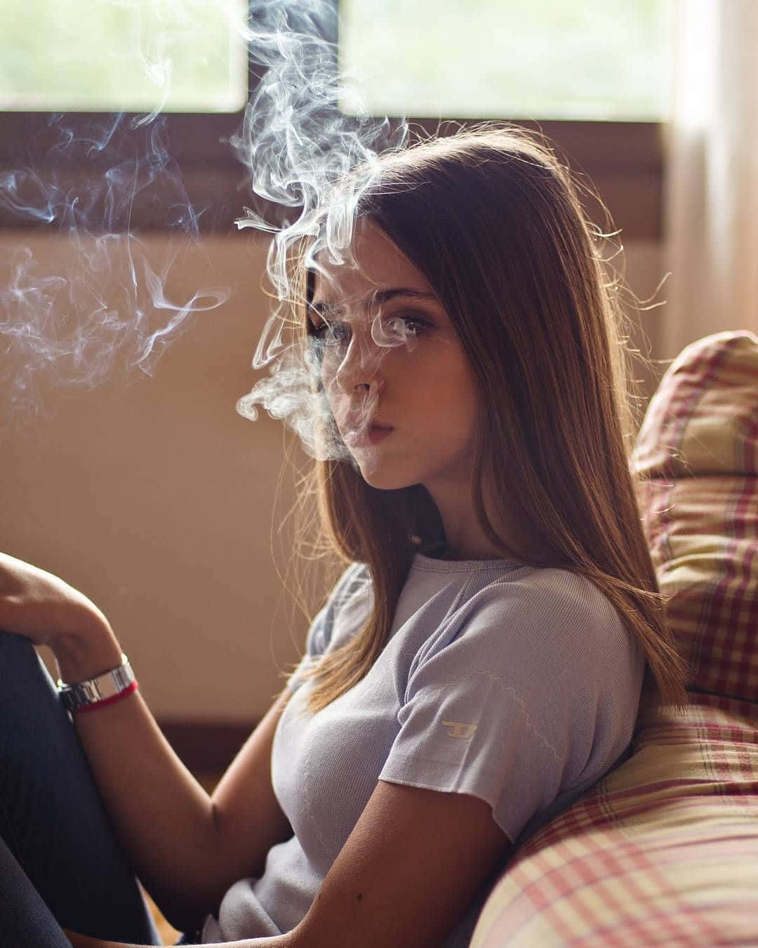 一個女孩坐在梳化上吸煙 壁紙