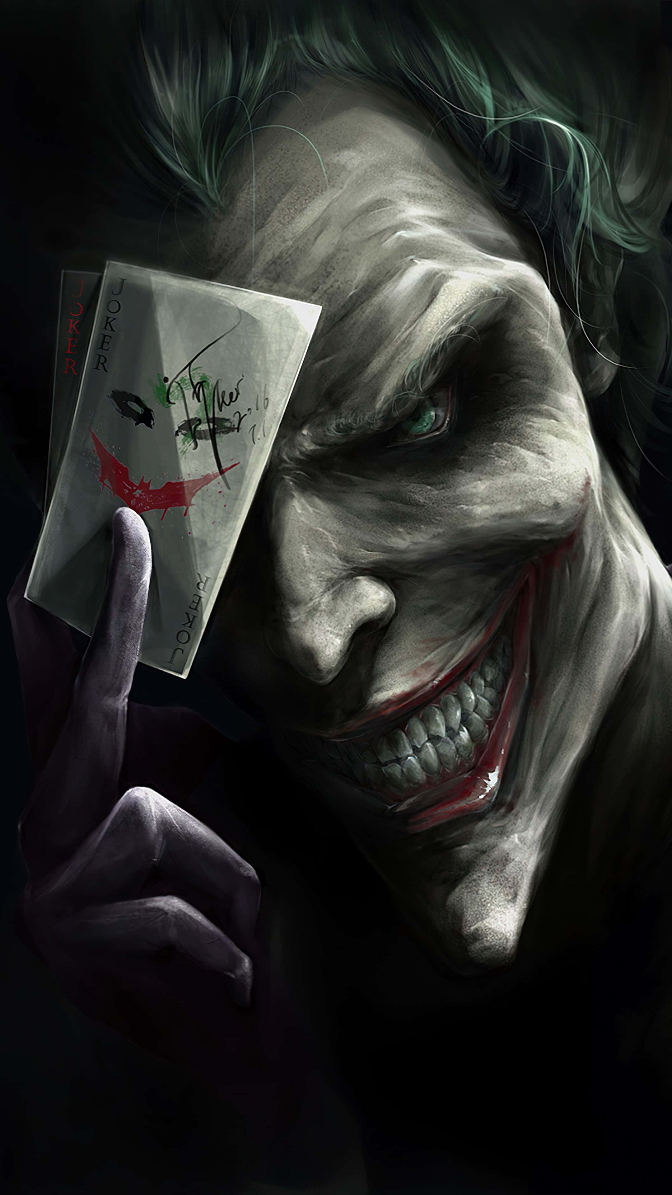 Joker Card 桌布 壁紙 — 一個威脅性的特寫鏡頭，小丑在黑暗背景下拿著小丑撲克牌，露出陰險的笑容。