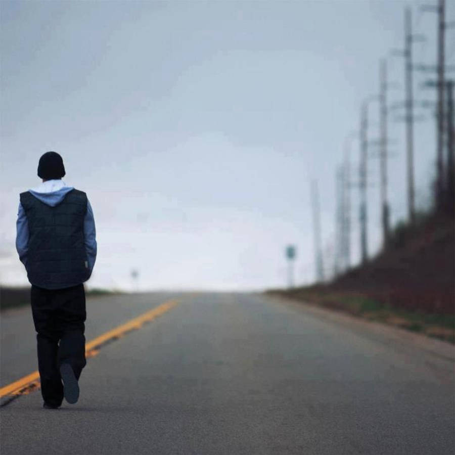 Alone Boy 桌布 壁紙 — 一個孤獨的人沿著一條空曠的長路走遠，天空多雲，電線杆在遠方逐漸消失。