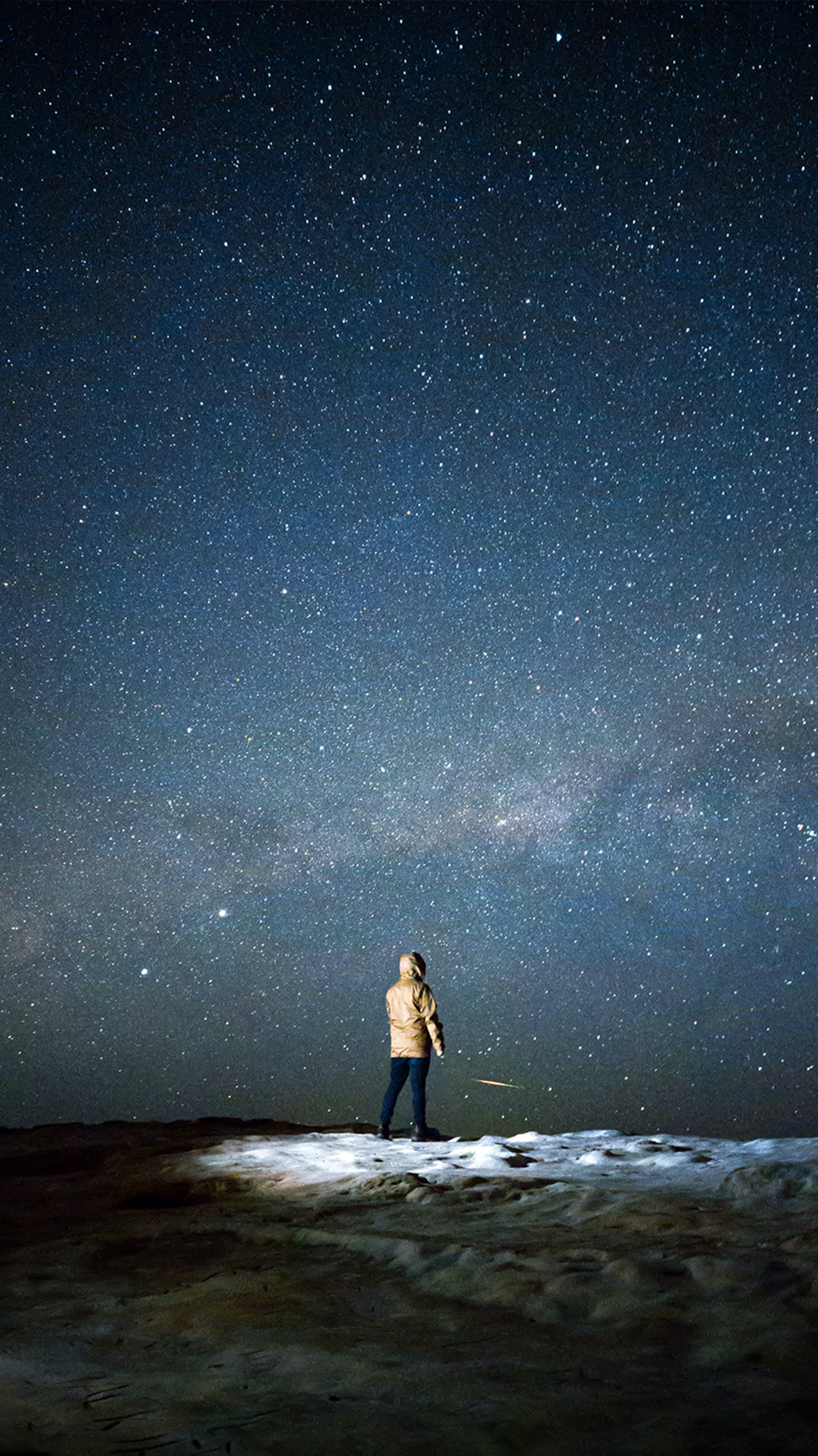 夜空 桌布 壁紙 — 一個孤獨的人站在白雪覆蓋的山頂上，腳下是令人屏息的星空夜空，銀河在上方閃耀。