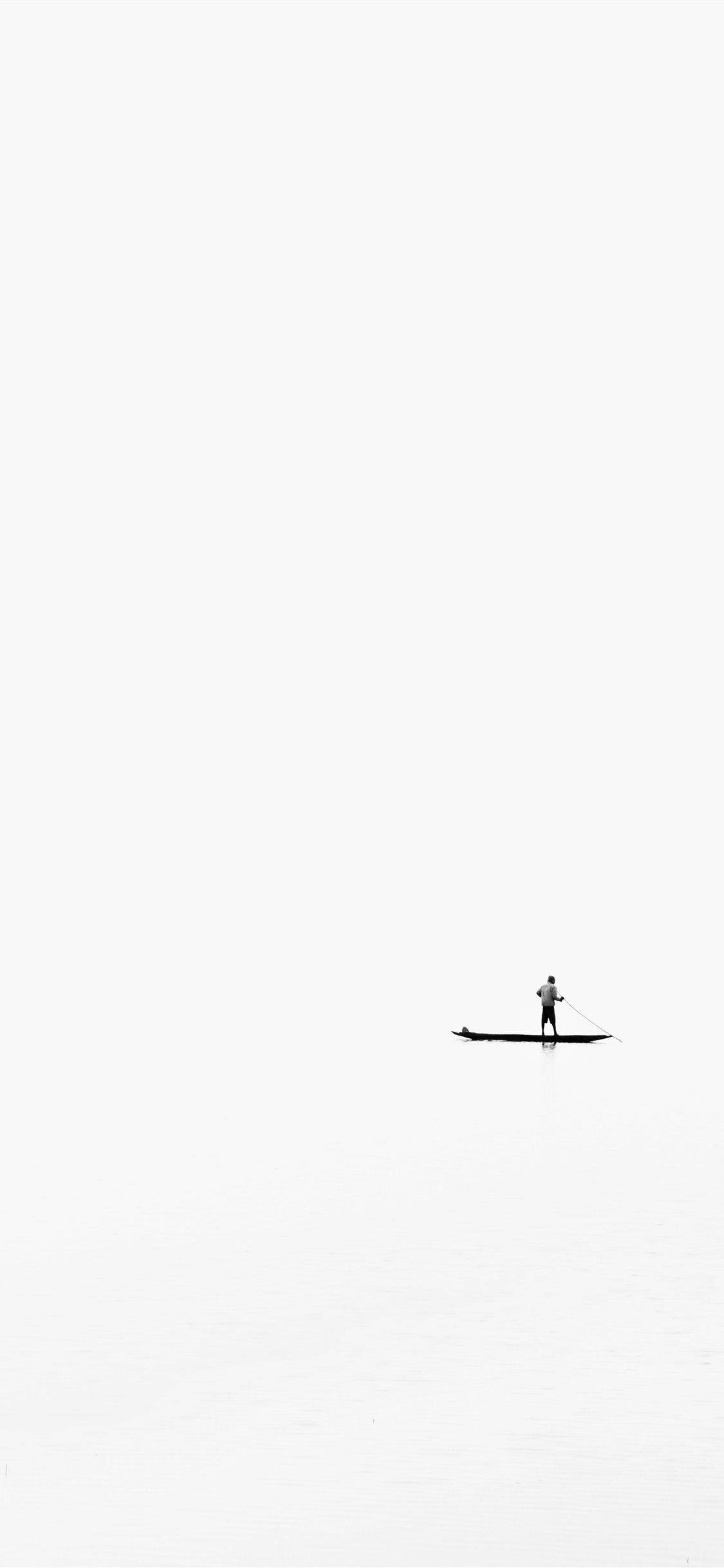 Rowing 桌布 壁紙 — 一個孤獨的槳板划手在蒼白的天空下，滑過一片無邊無際、霧氣瀰漫的白色水面。