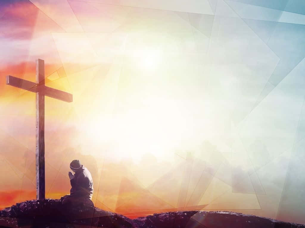 Gospel 桌布 壁紙 — 一個孤獨的身影在日落時分跪在木十字架前祈禱，背後有耀眼的光芒迸發。