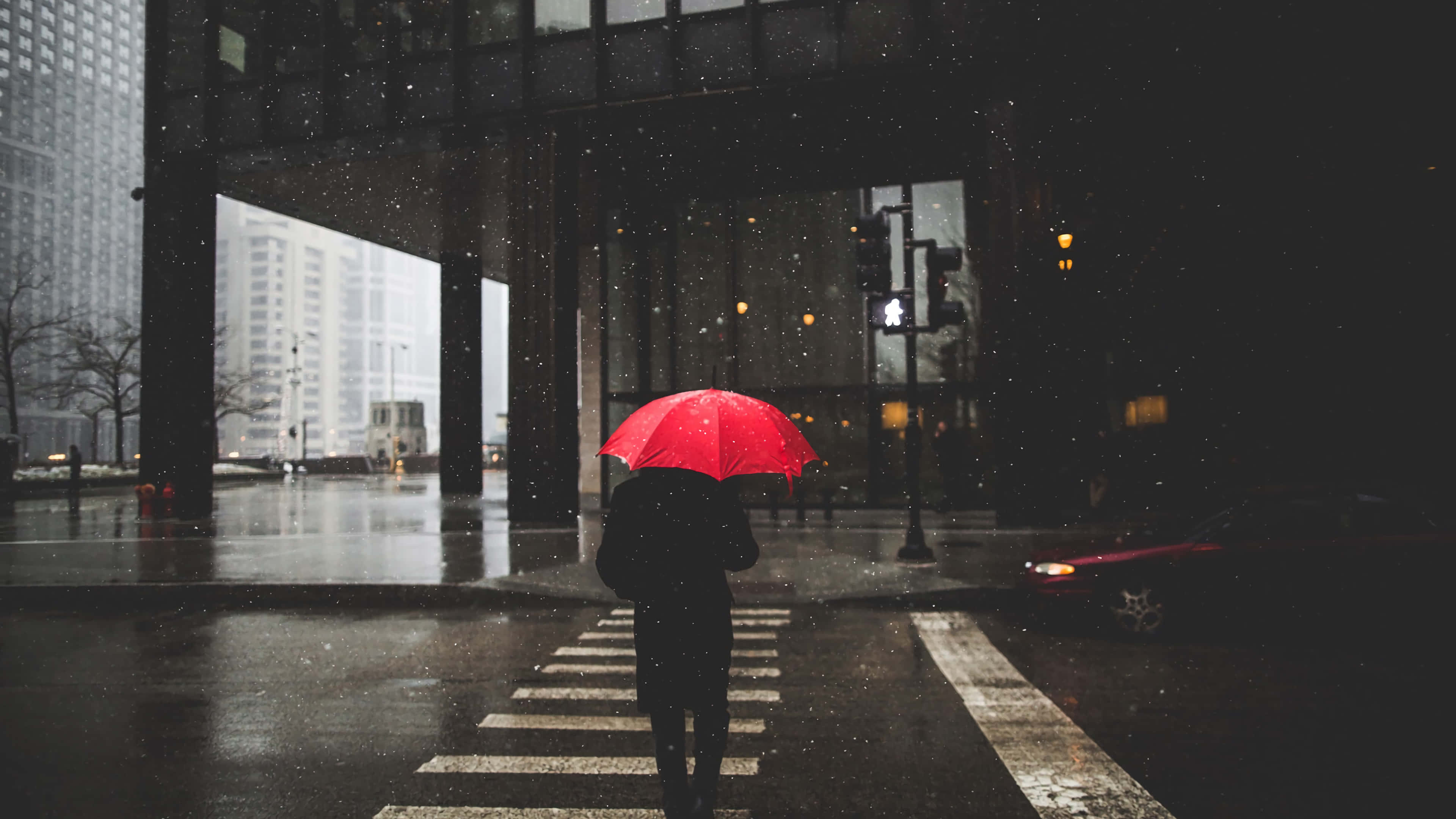 Raining 桌布 壁紙 — 一個孤獨的身影撐著鮮紅色雨傘，在夜晚的雨中走過濕漉漉的城市街道。