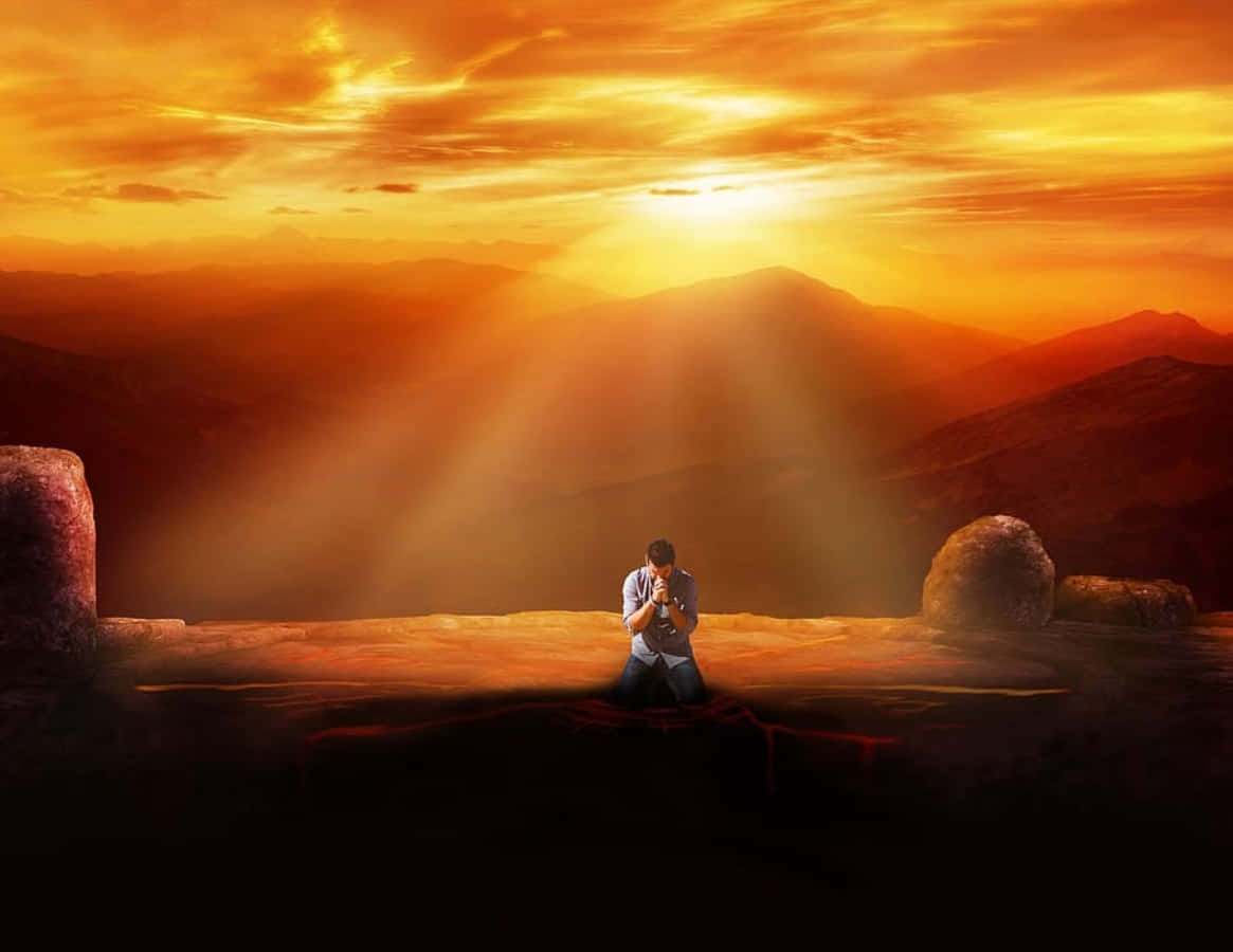 Spirituality 桌布 壁紙 — 一個孤獨的身影跪在山脊上祈禱，夕陽的金色光芒穿透雲層。