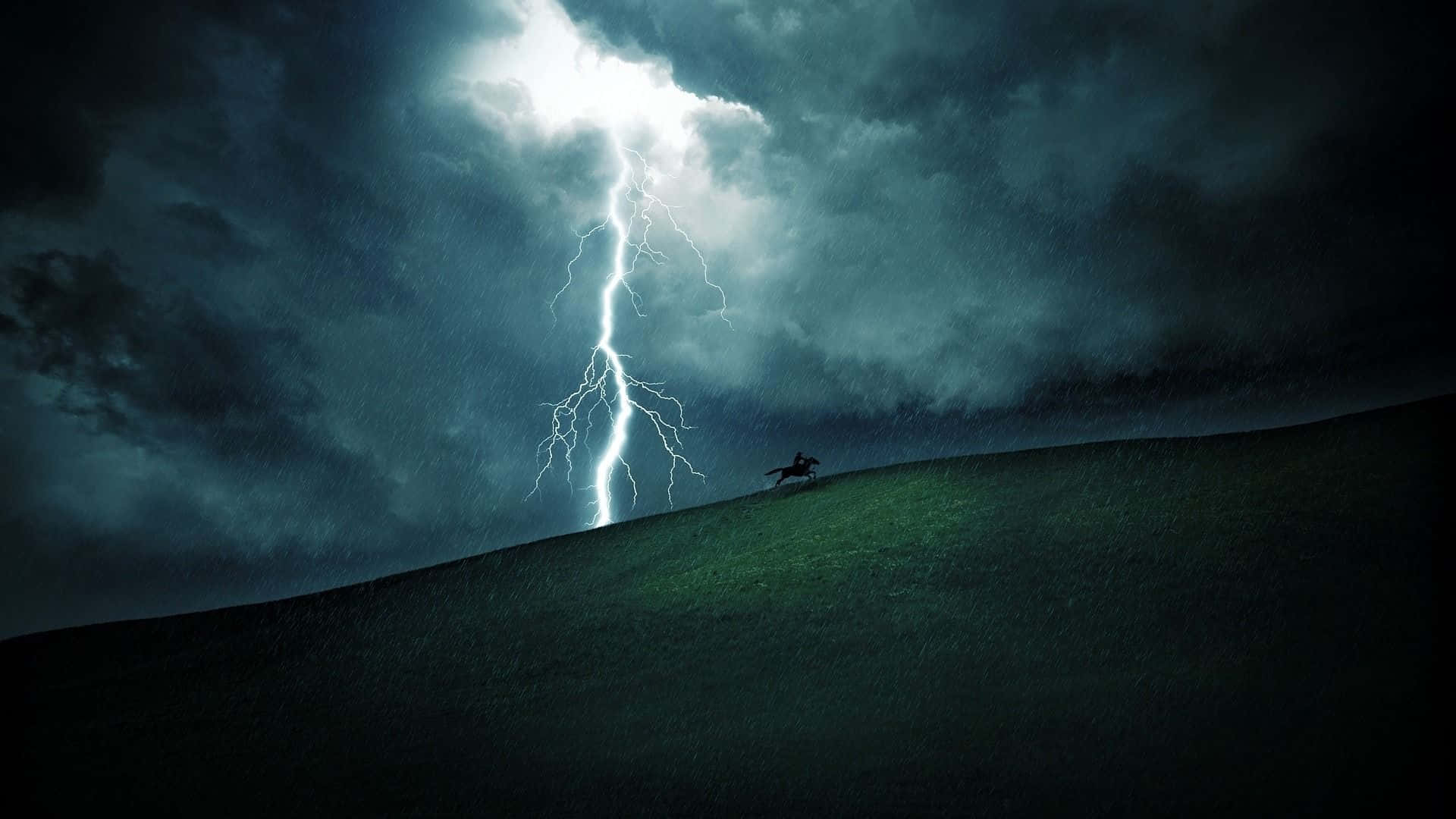 Thunderstorm 桌布 壁紙 — 一個孤獨的騎手騎在馬上，以戲劇性的山丘為背景形成剪影，一道巨大的閃電擊中上方暴風雨的天空。