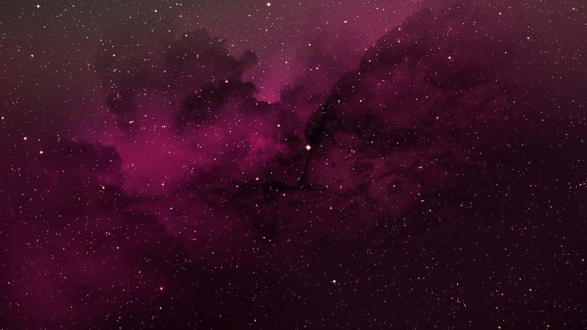 Red Space 桌布 壁紙 — 一個宇宙星雲在深洋紅色和黑色中旋轉，散落的星星在虛空中柔和地發光。
